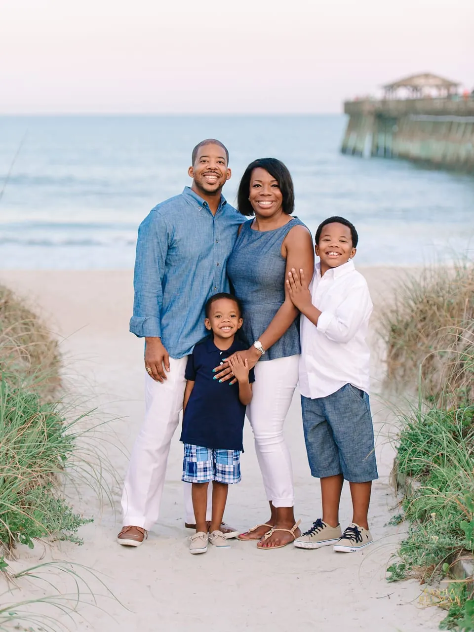 Blue and white family beach photo outfits with ocean backdrop