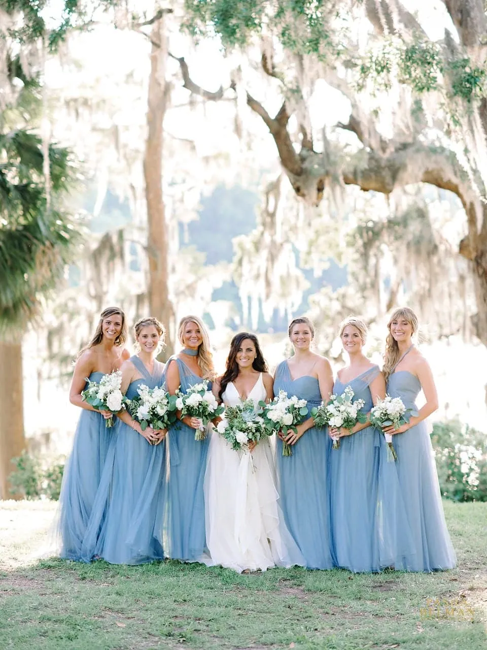 Bride with her bridesmaids in dusty blue dresses under the oaks at Wachesaw Plantation in Murrells Inlet, SC