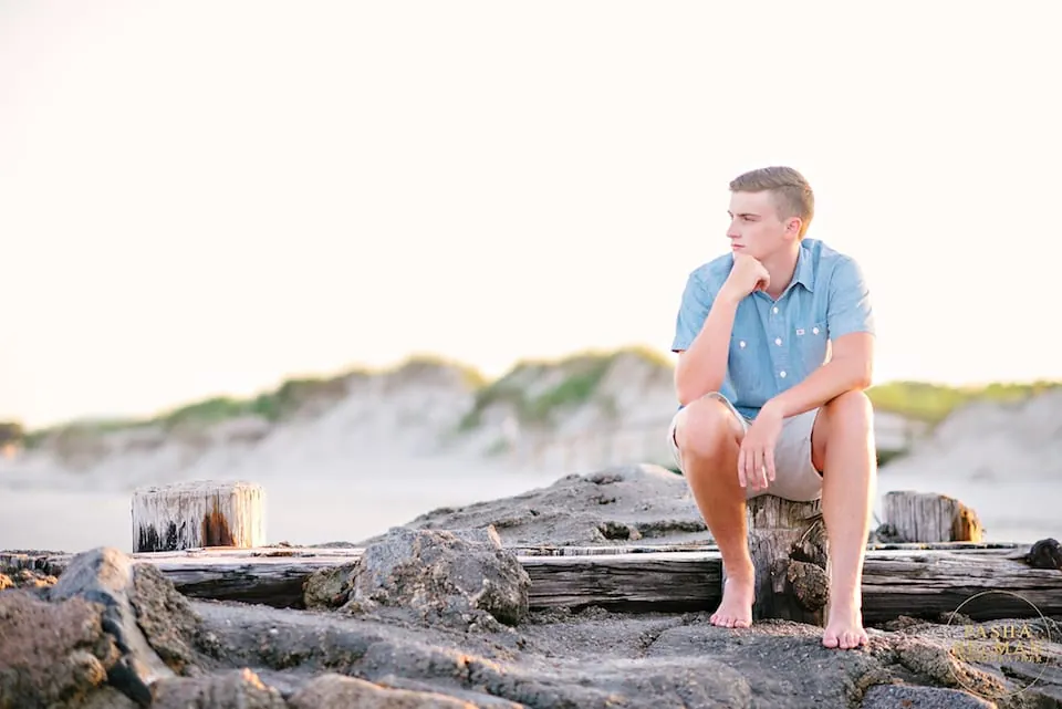 Senior guy portrait leaning against a tree near Myrtle Beach greenery