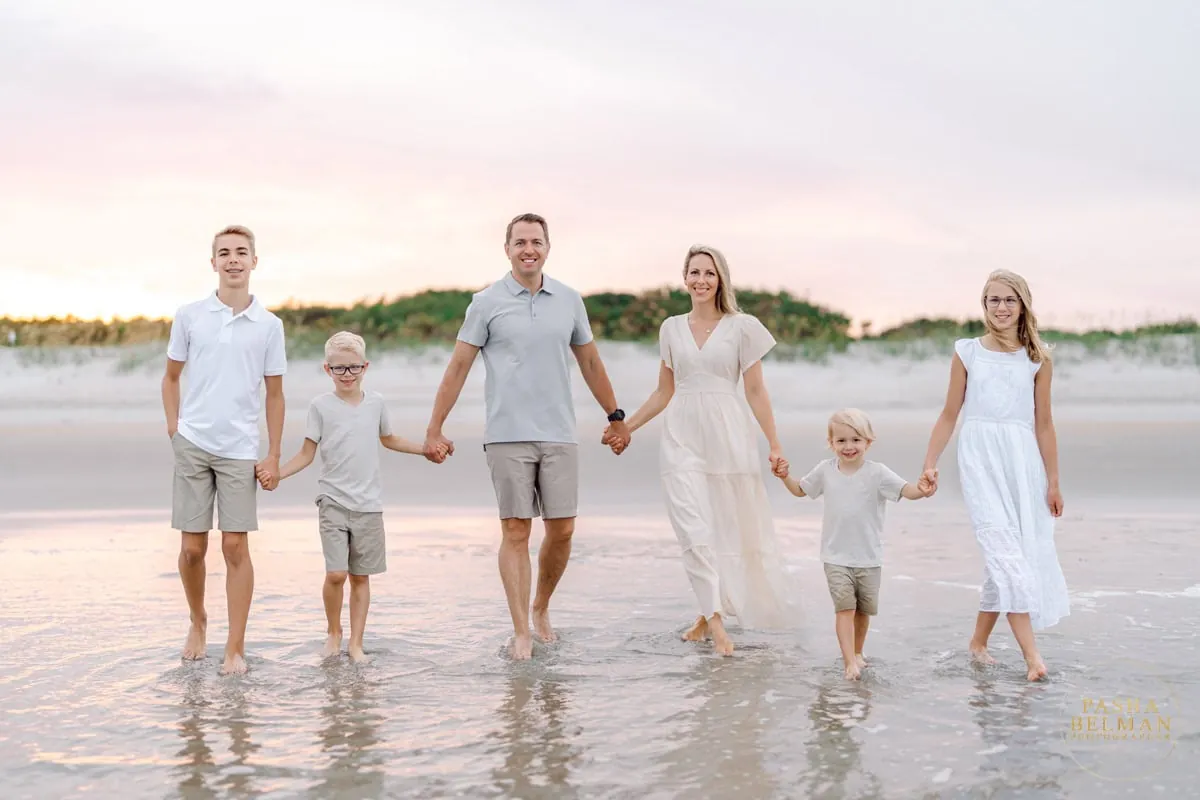 Blush tan and white family beach photo outfits with soft sunset light