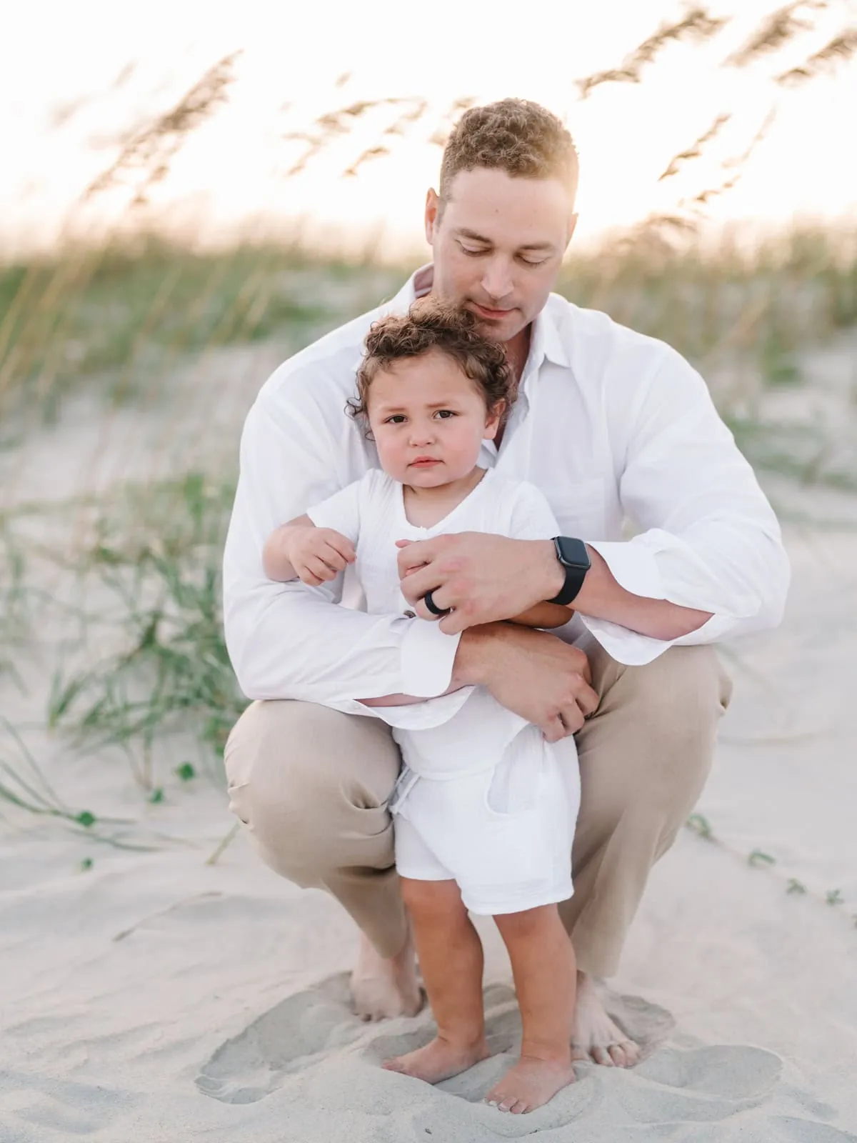 Casual coordinated outfits for men and boys photographed during beach family session
