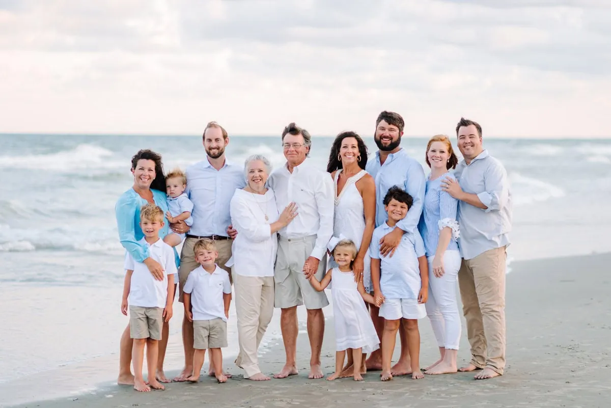 Family wearing blue and white coordinated outfits during beach family photography session