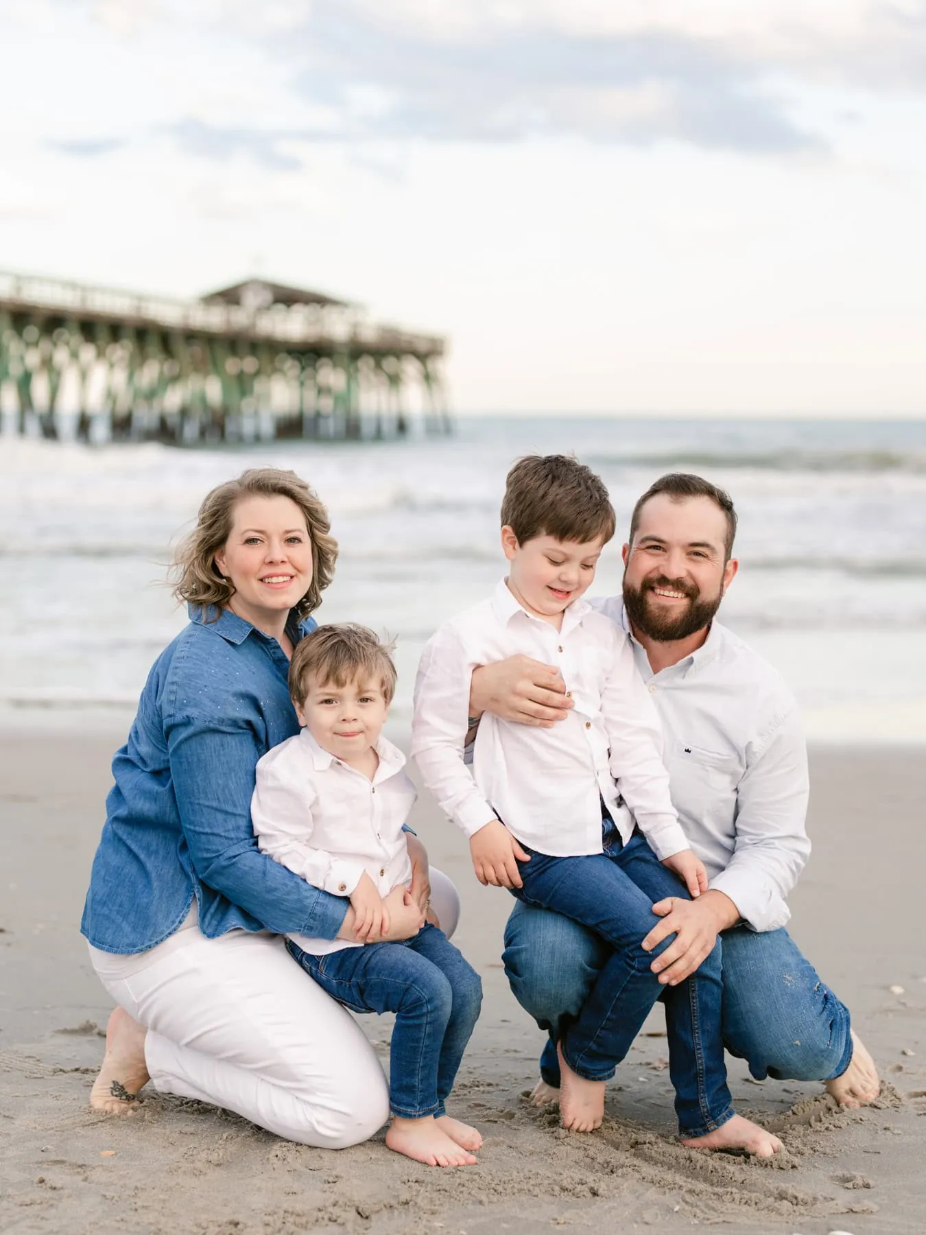 Family sitting together in the sand during a Myrtle Beach portrait session