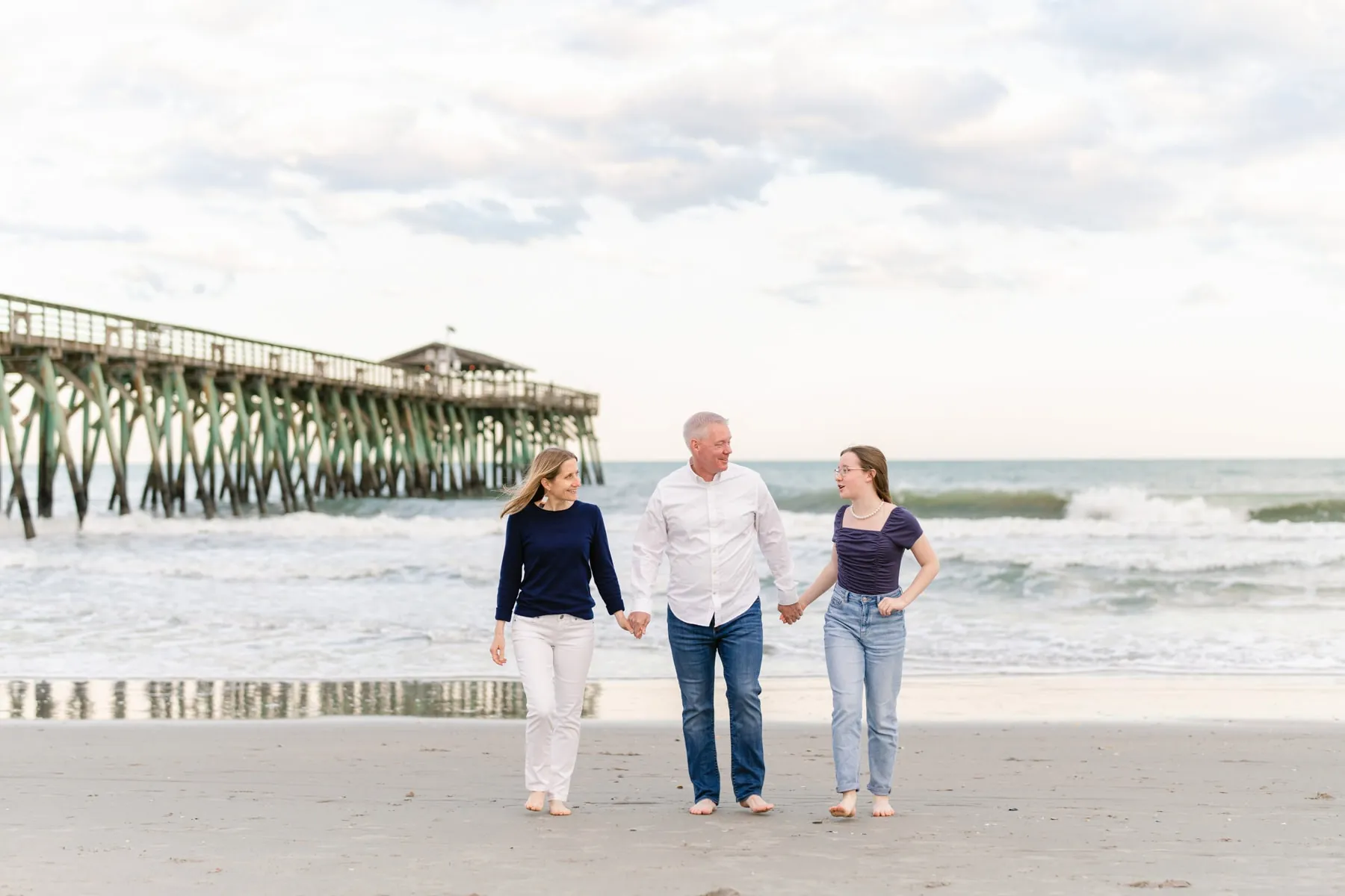 Parents lifting their child in the air on the Myrtle Beach shore