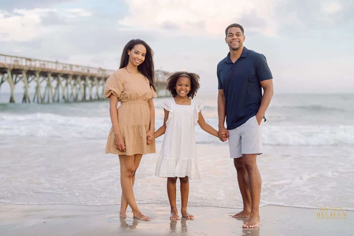 Parents and children posing on sandy dunes at golden hour during a Myrtle Beach family beach portrait session