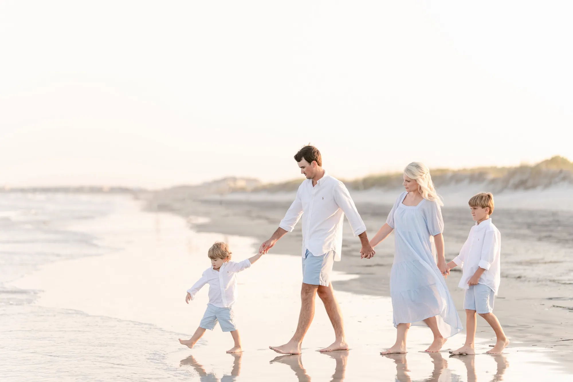 Family laughing together on the beach during a professional photo session in Myrtle Beach, SC