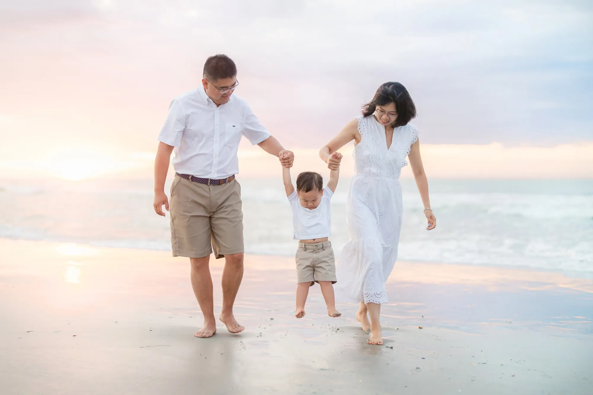 Family smiling and relaxed during an early morning beach portrait session in Myrtle Beach, South Carolina