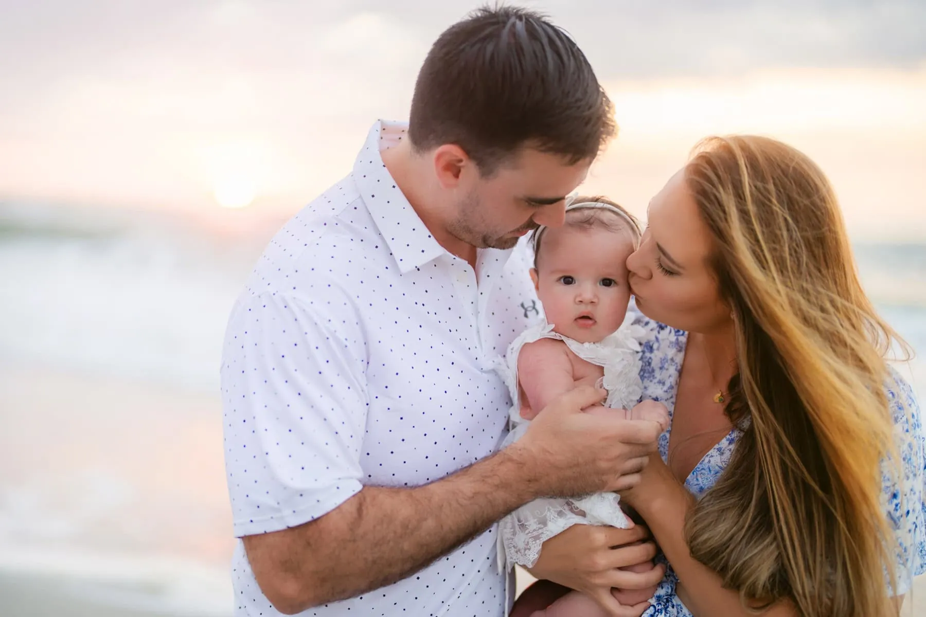 Family walking together at sunrise on a Myrtle Beach shoreline during a professional beach portrait session