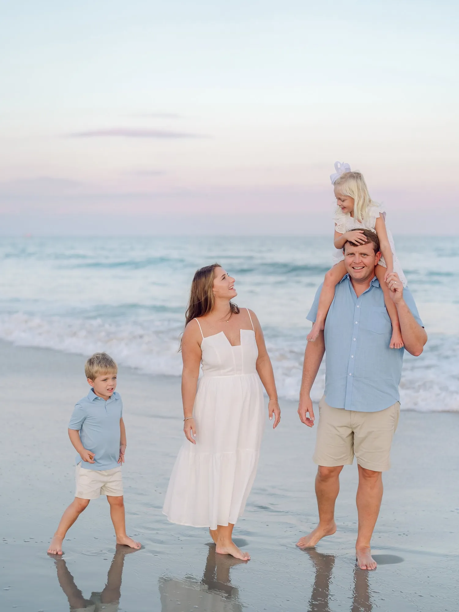 Parents and teenage children posed together with Huntington Beach maritime forest background