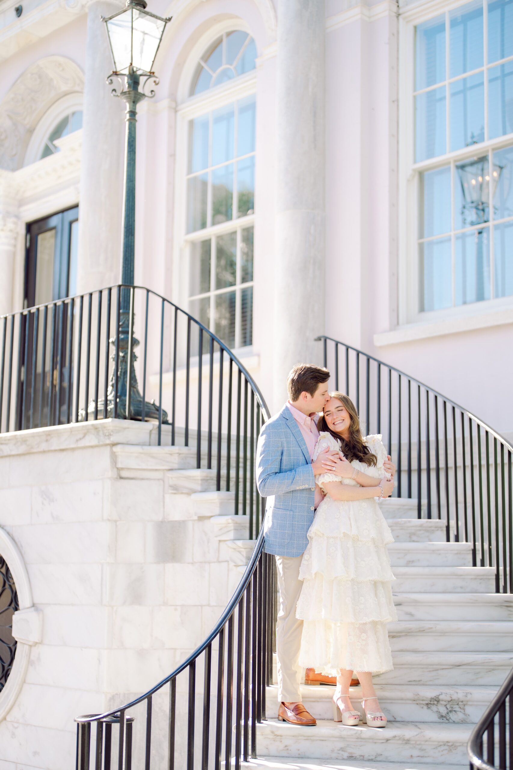 Romantic Charleston SC engagement photo with couple posing on grand staircase of iconic downtown venue
