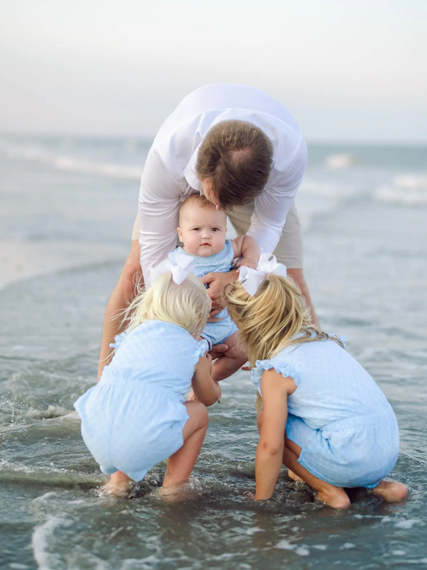Family gathered together along the South Carolina shoreline at sunset
