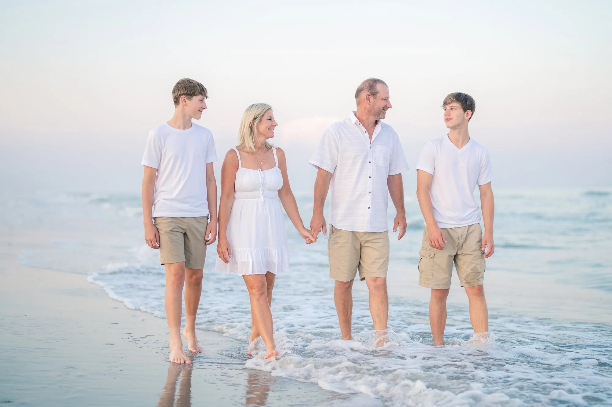 Family walking along the shoreline during a beach portrait session in Myrtle Beach SC