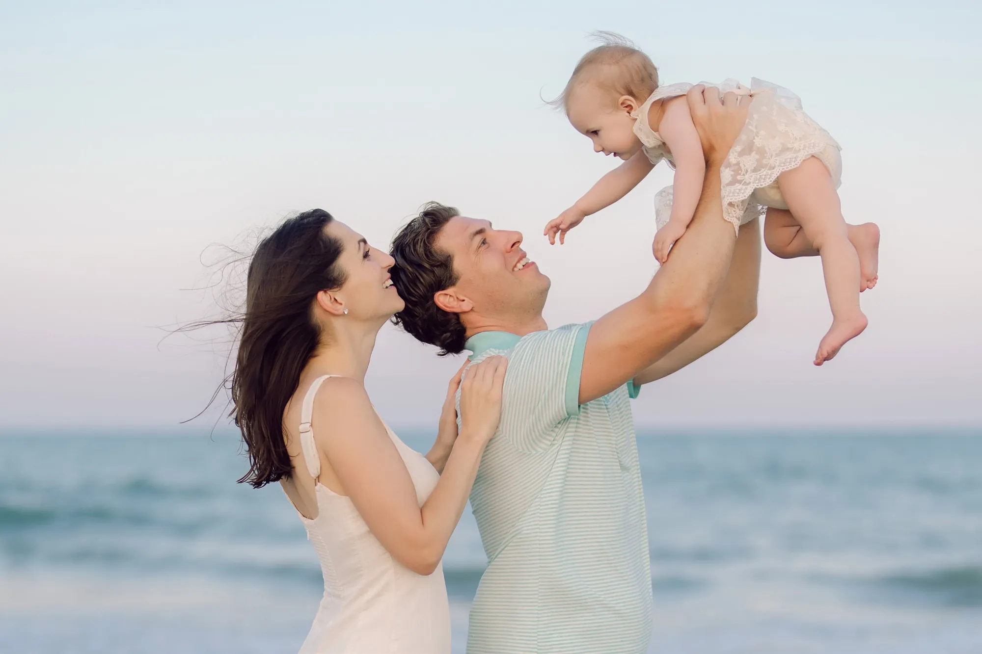 Toddlers and parents playing on Garden City beach, candid joyful family moment