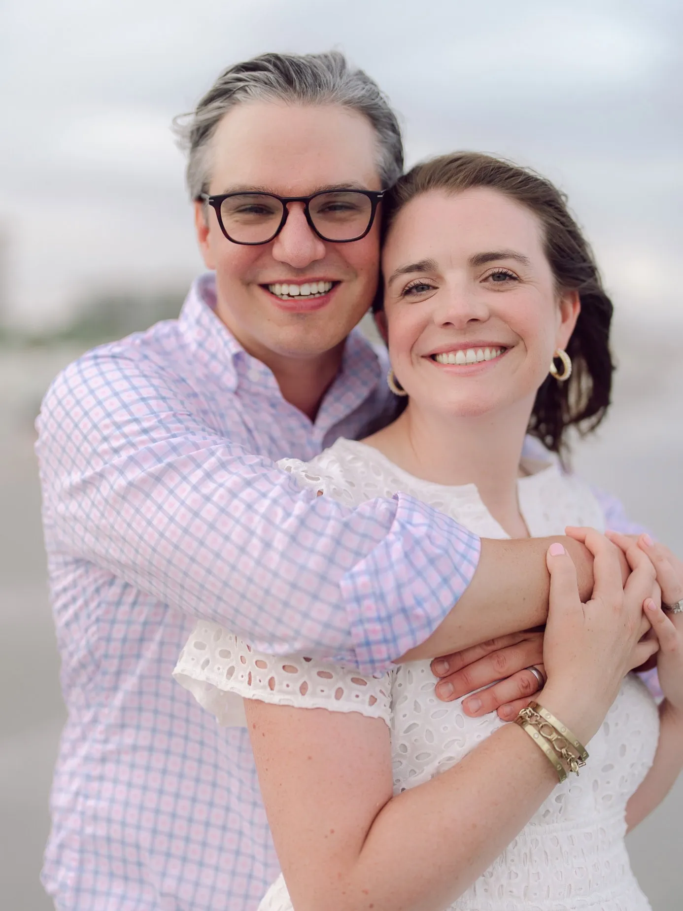 Couple embracing near the water during their extended family beach session in Myrtle Beach