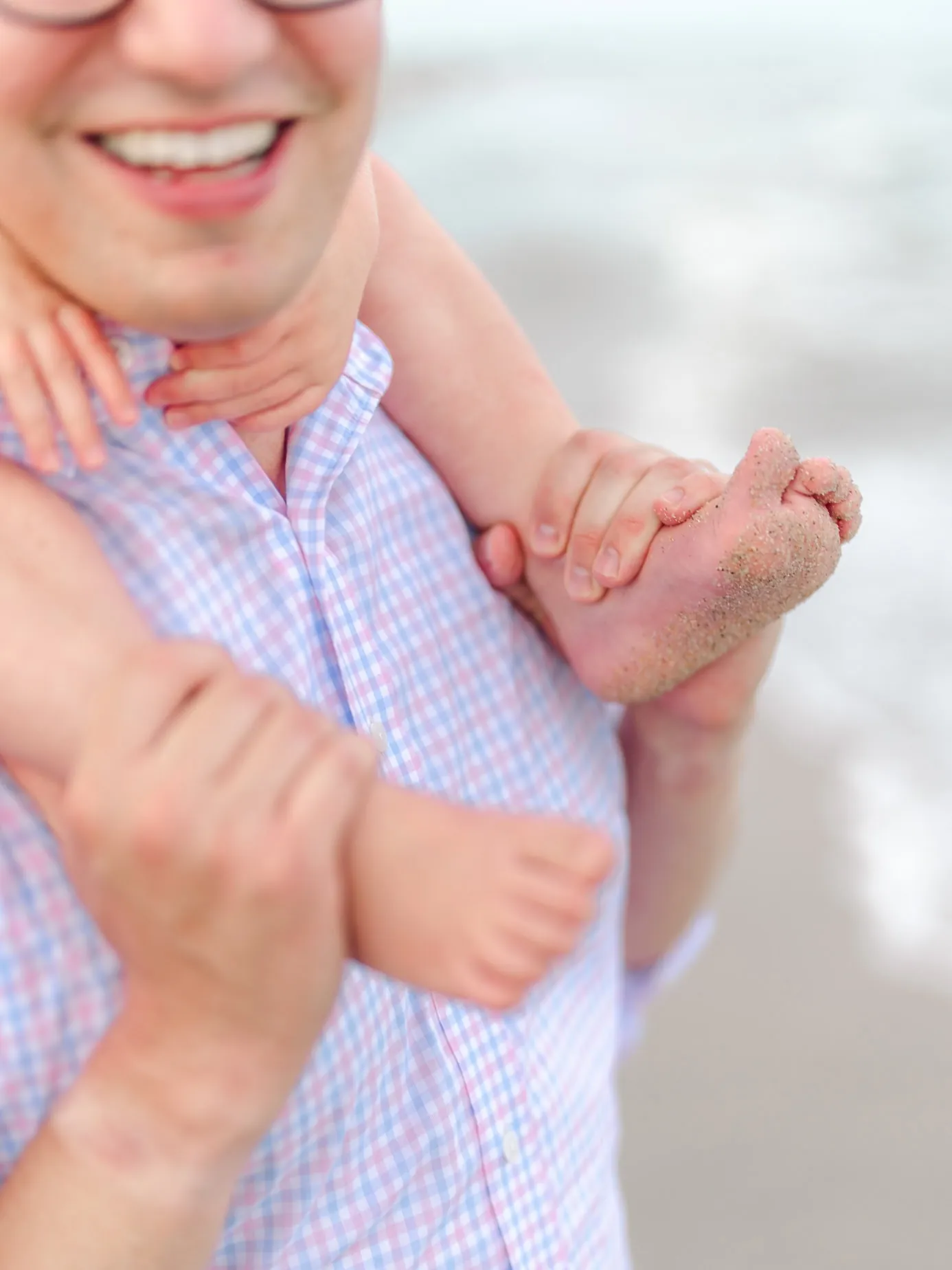 Playful father and child moment photographed during their family beach vacation