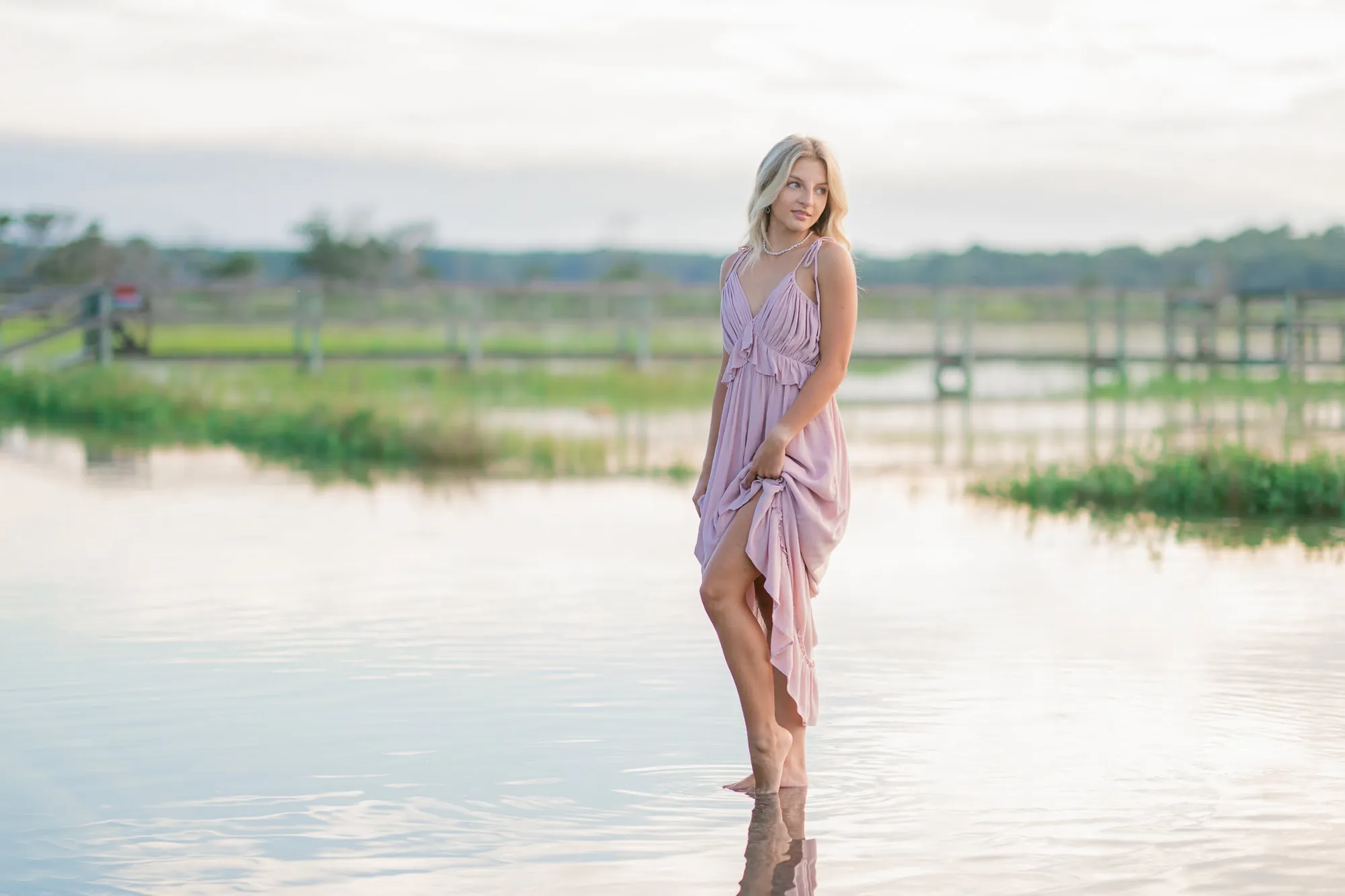 Senior portrait photographed near the water along the South Carolina coast with calm background and natural expression by Pasha Belman