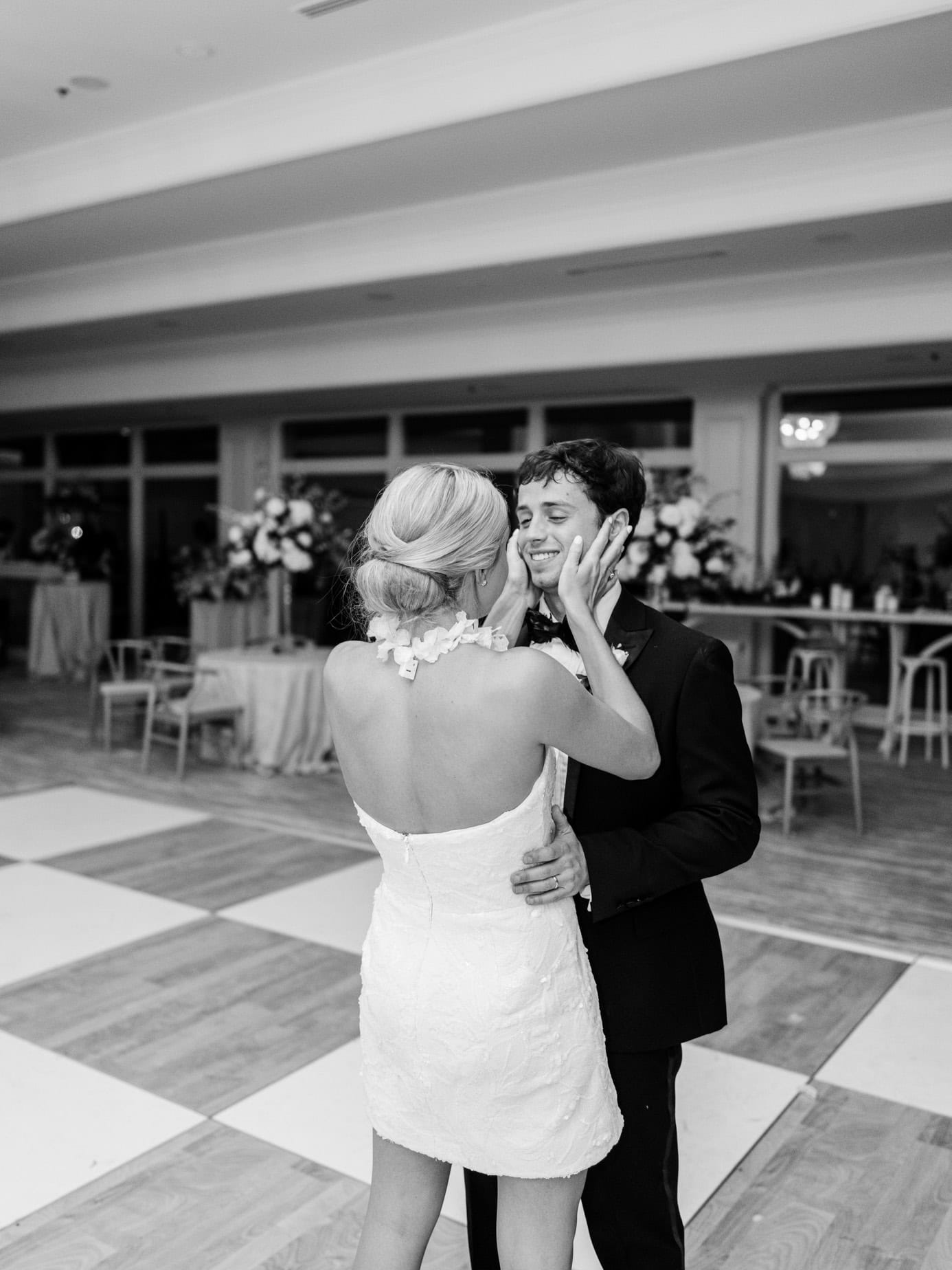 Elegant wedding couple dancing at reception, romantic moment captured in black and white.