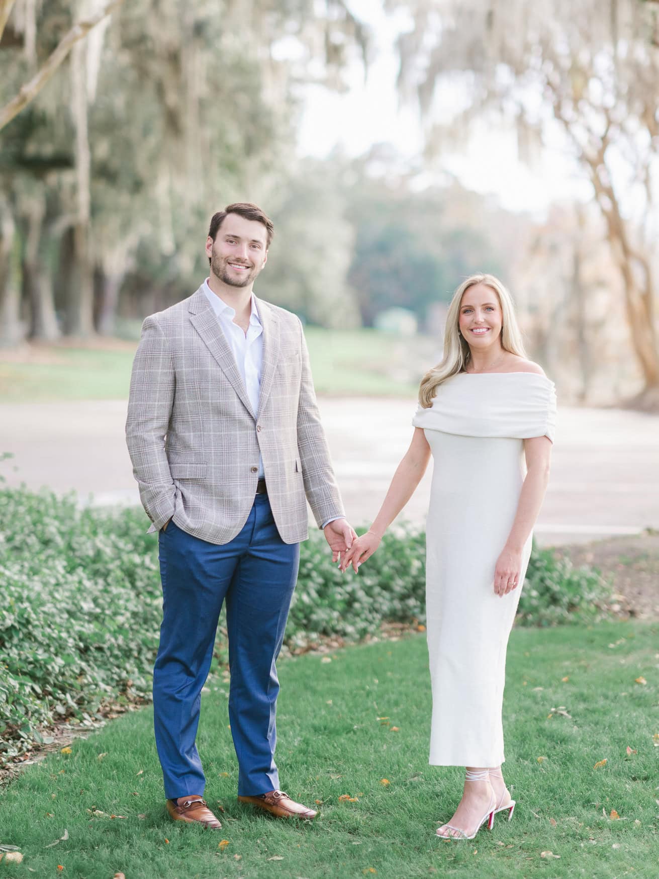 Romantic engagement photography at Caledonia Golf and Fish Club Pawleys Island SC with couple walking hand in hand under oak trees