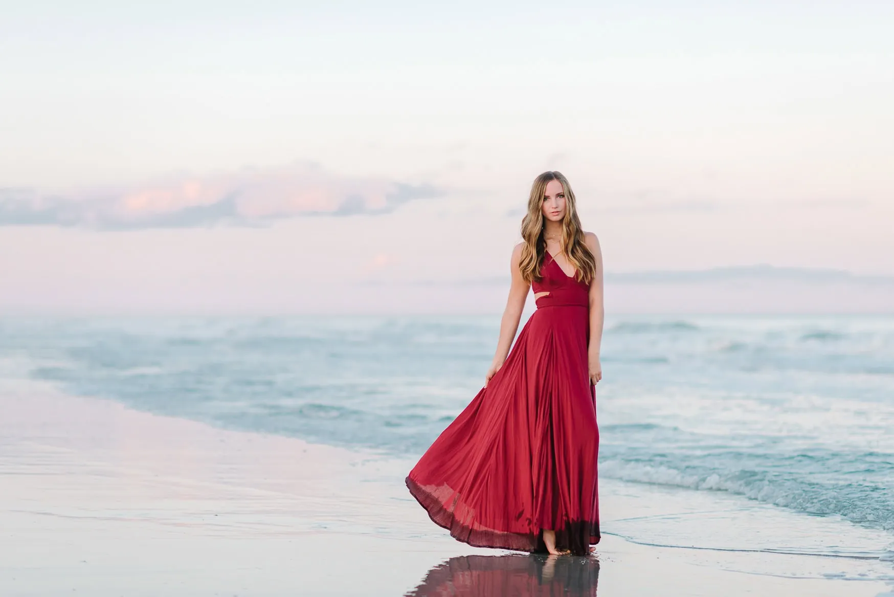 Elegant senior beach portraits with natural movement and soft sunset light