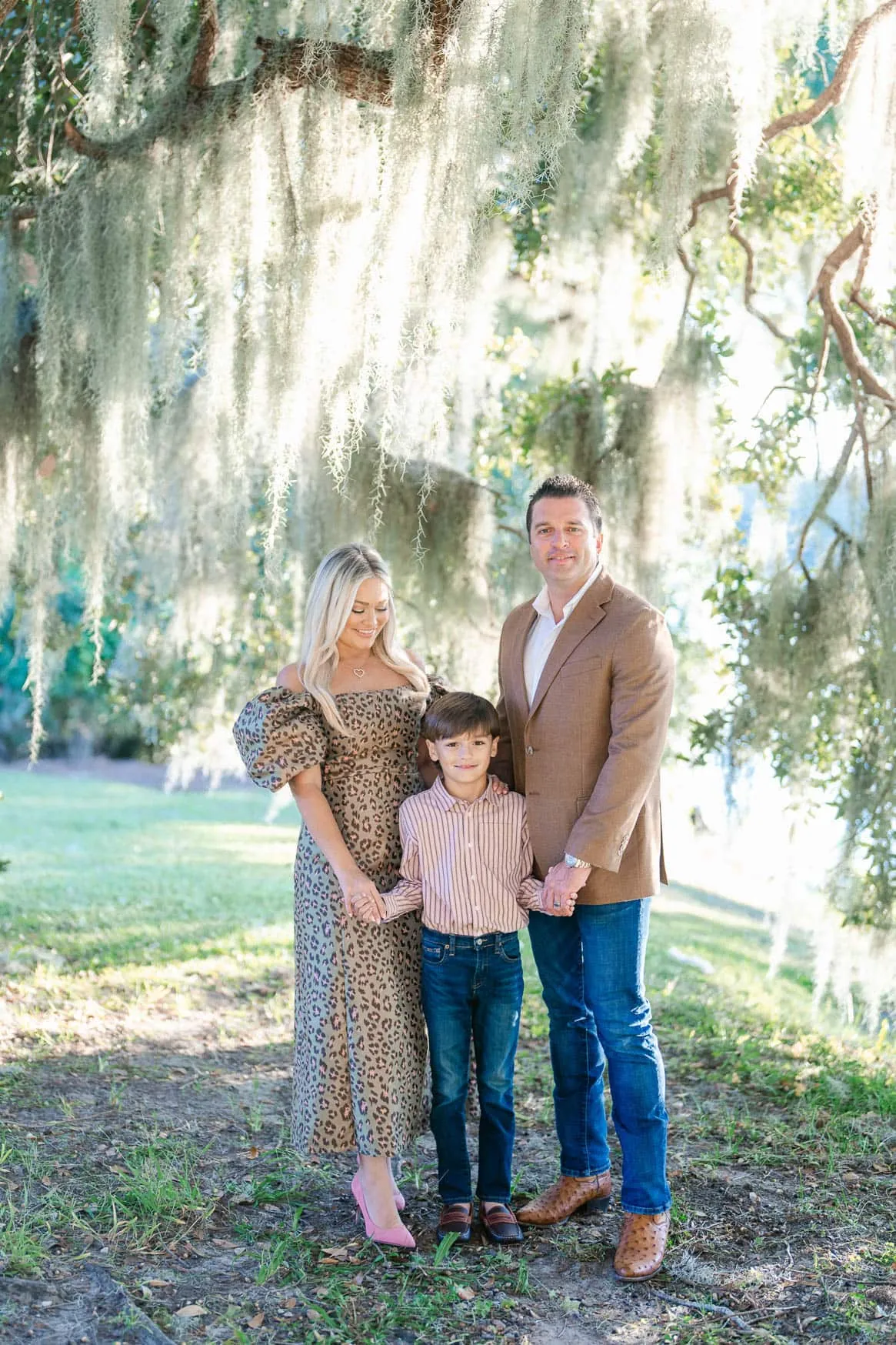 Family holding hands beneath Spanish moss during their Murrells Inlet portrait session