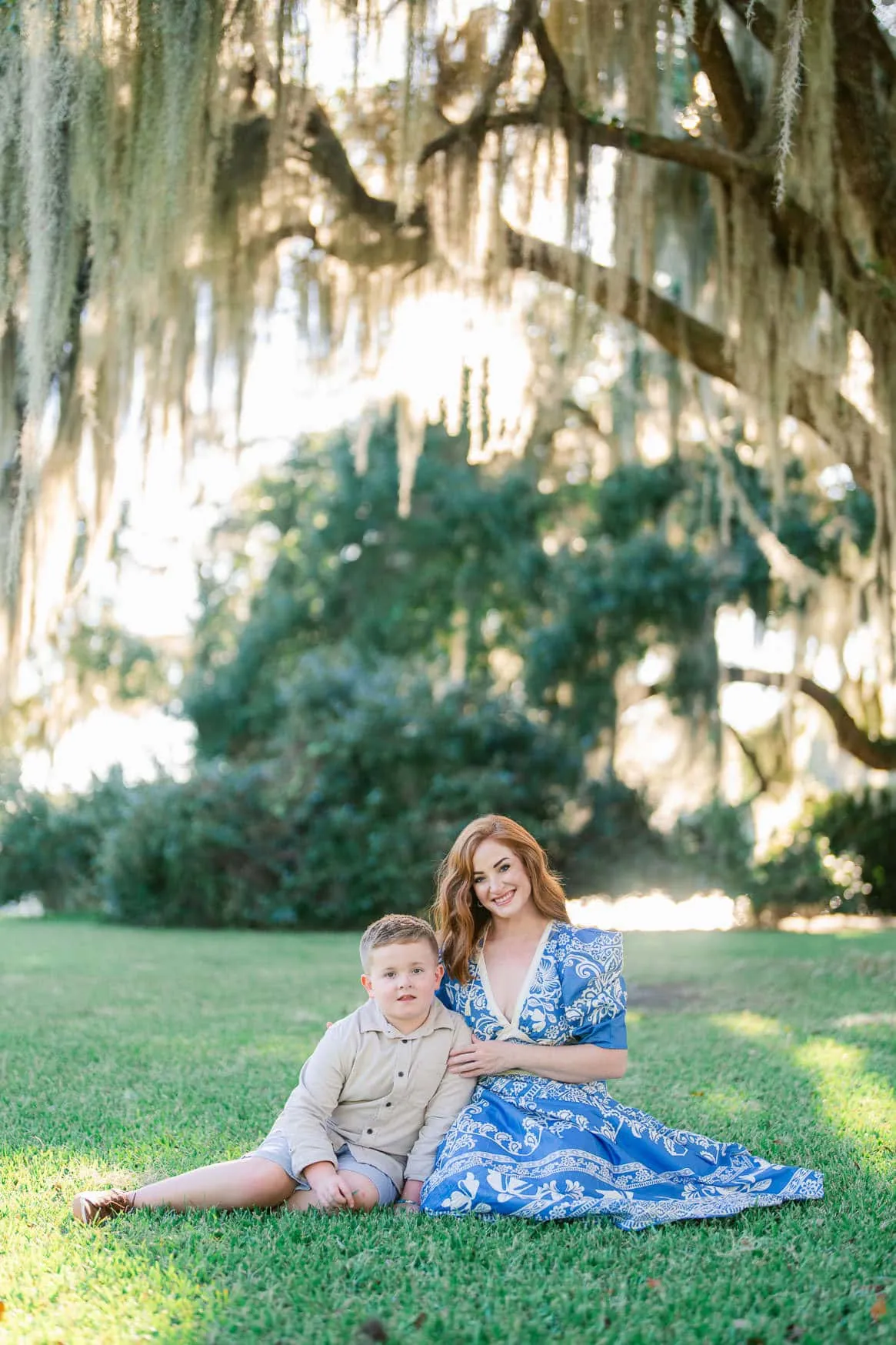Mother and son sitting together beneath the oak trees at Wachesaw