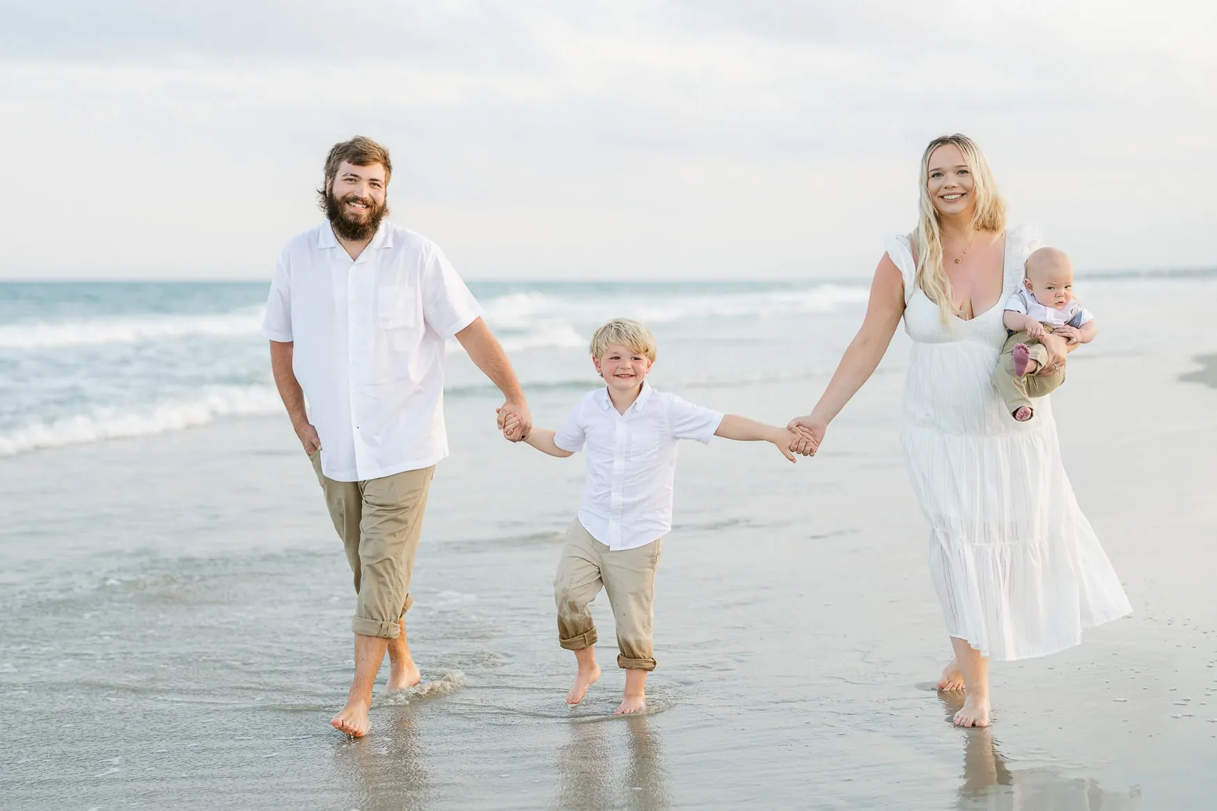 Parents and children walking along the shoreline during a Surfside Beach family portrait session