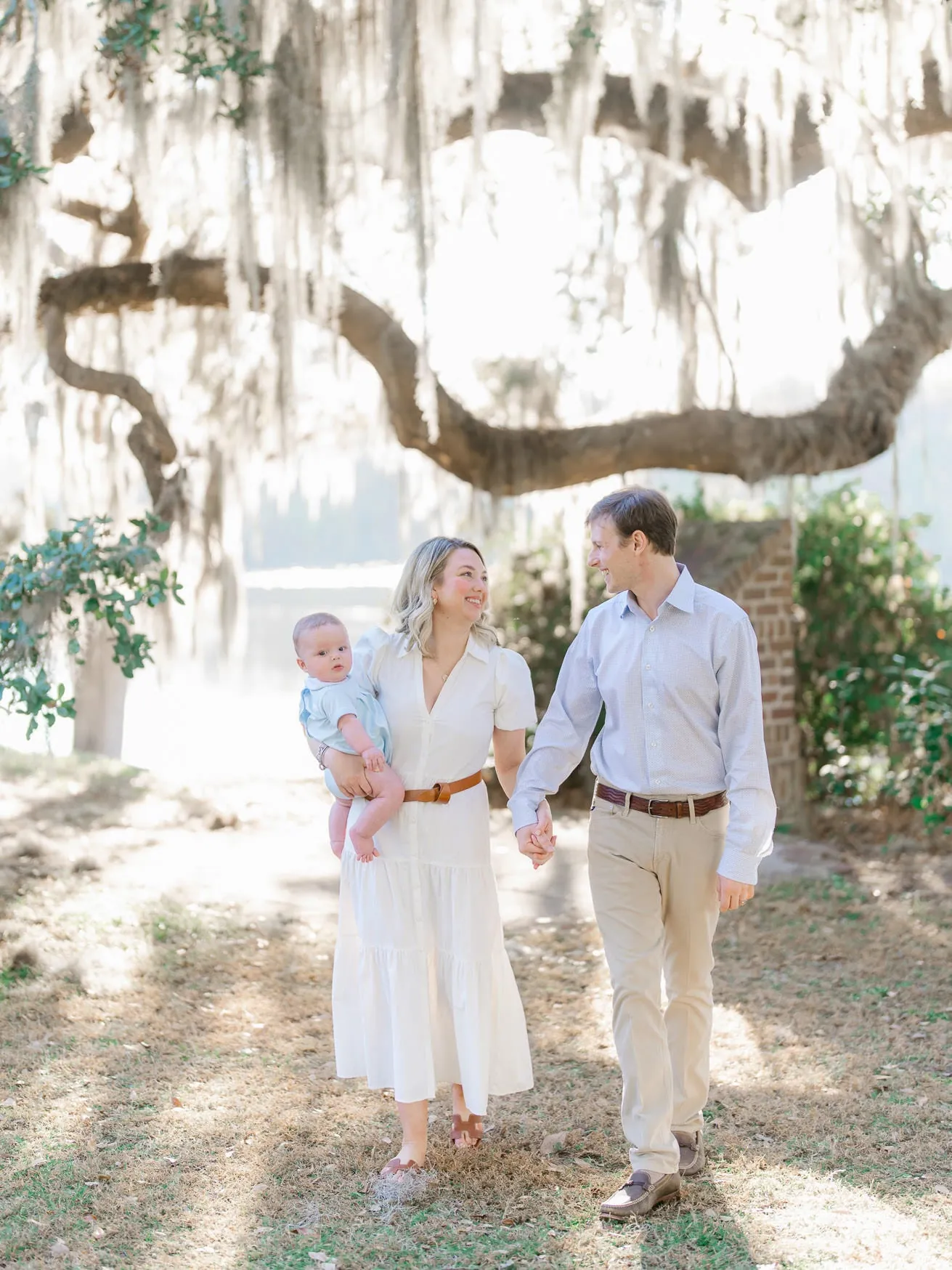 Parents with their baby beneath Spanish moss during a Wachesaw family session