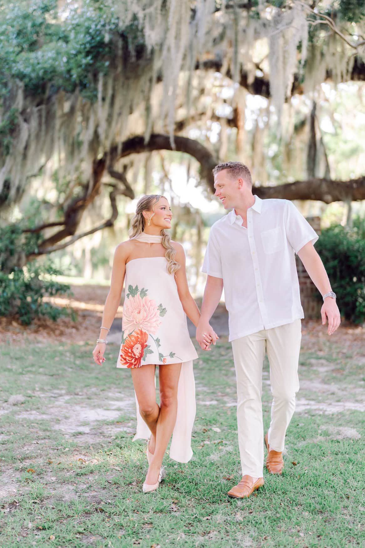 Engaged couple walking through the Pawleys Island live oak corridor during their Grand Strand engagement session