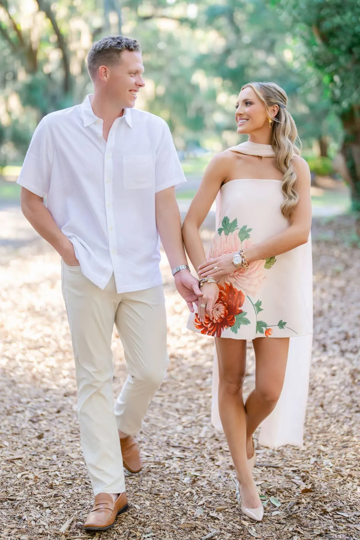 Bride to be in blush floral cape dress standing under a live oak arch during Pawleys Island engagement session