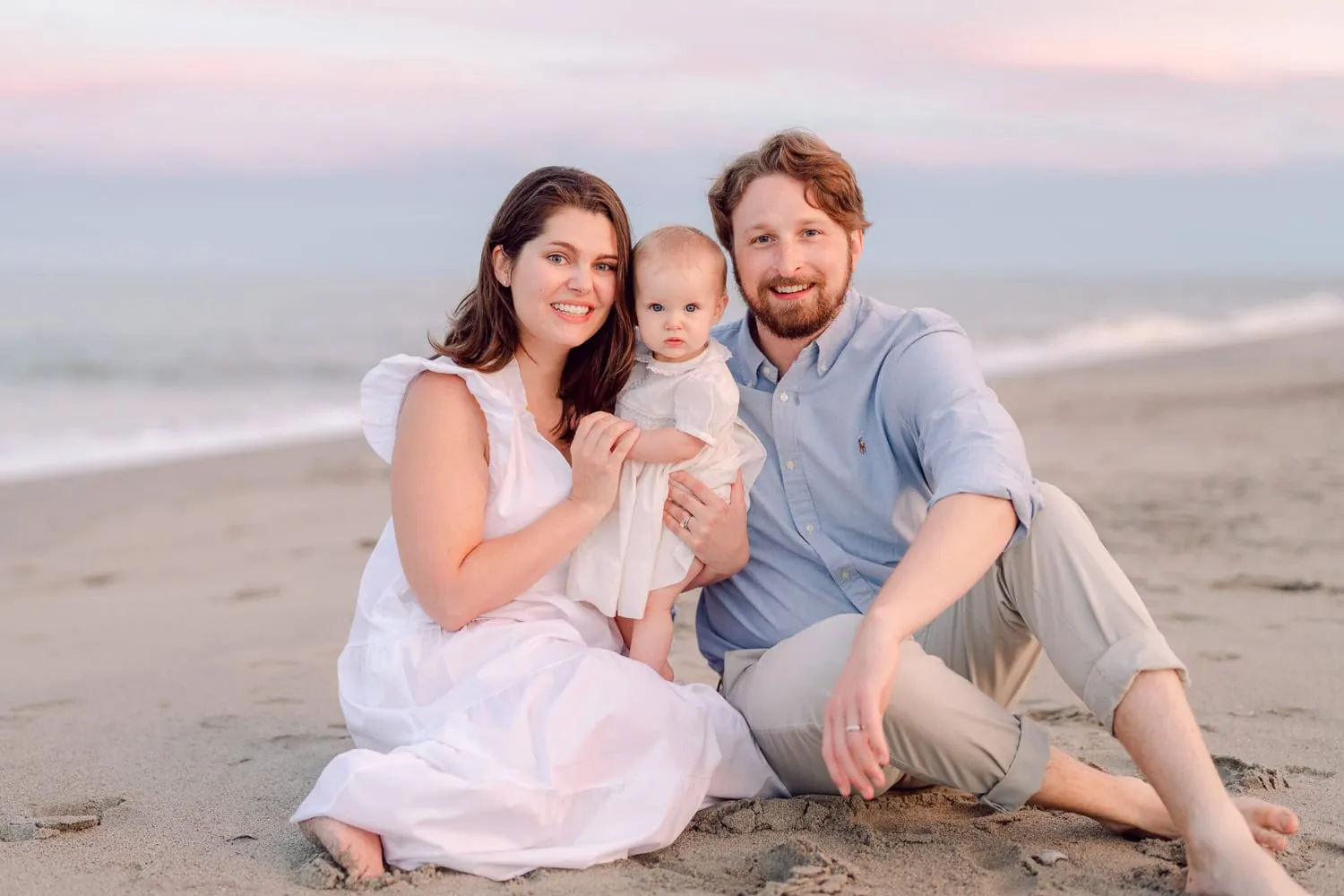 Family wearing coordinated soft blue, white, and neutral outfits for family beach photos in Myrtle Beach, South Carolina.
