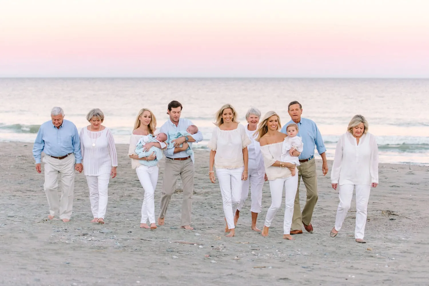 Family wearing coordinated white, cream, and neutral outfits for family beach photos in Myrtle Beach, South Carolina.