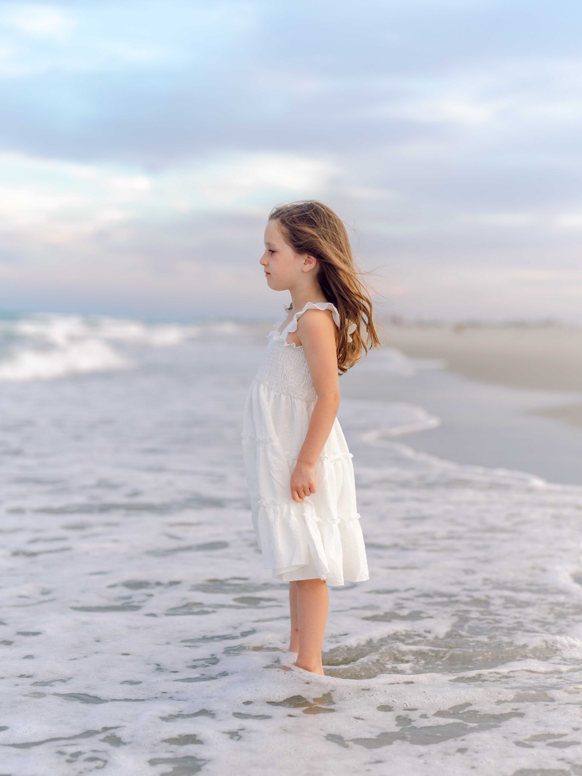 Young girl smiling on the beach during a Pawleys Island family photography session.