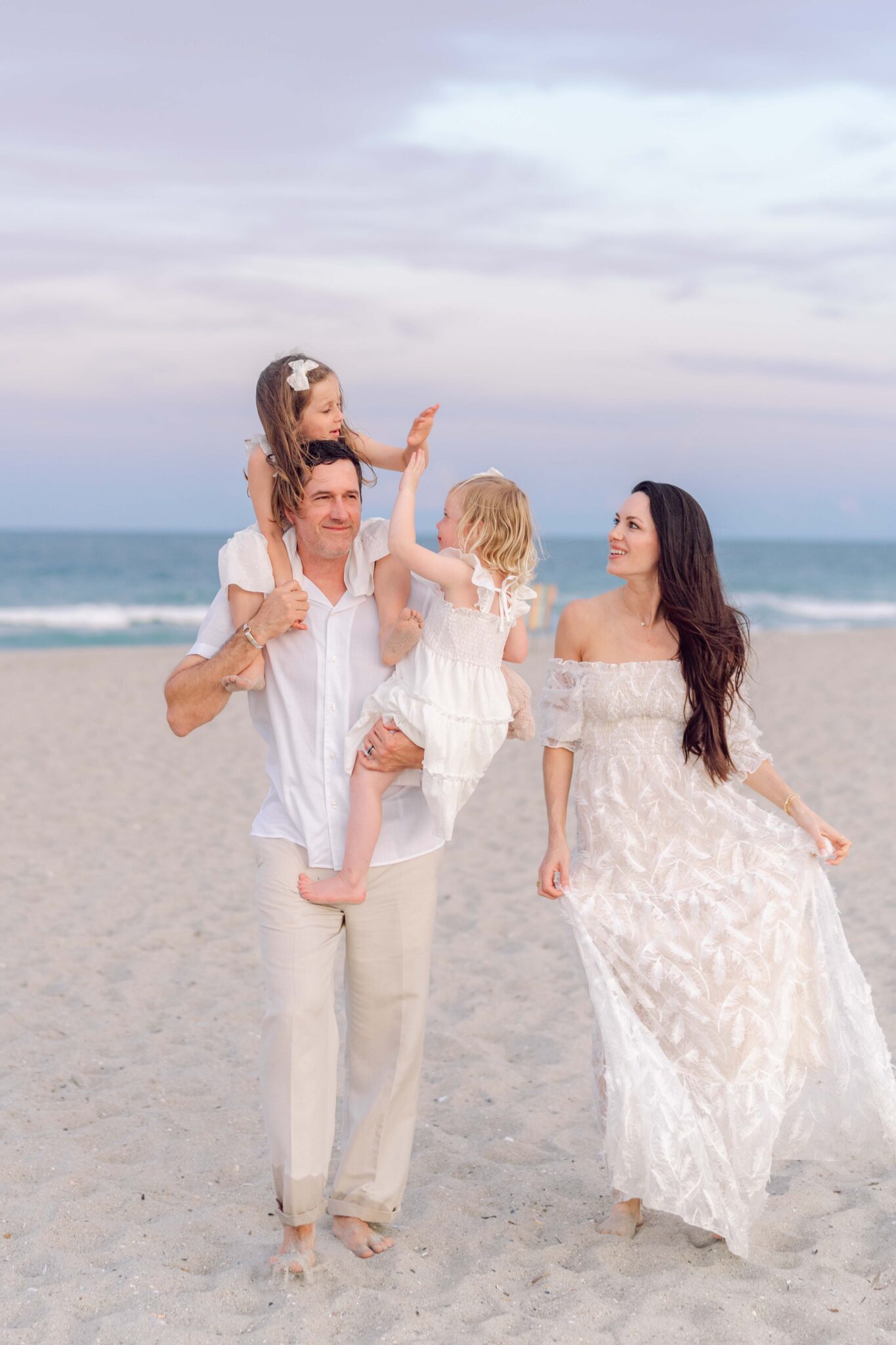 Father carrying both daughters during a relaxed Pawleys Island beach family photography session.