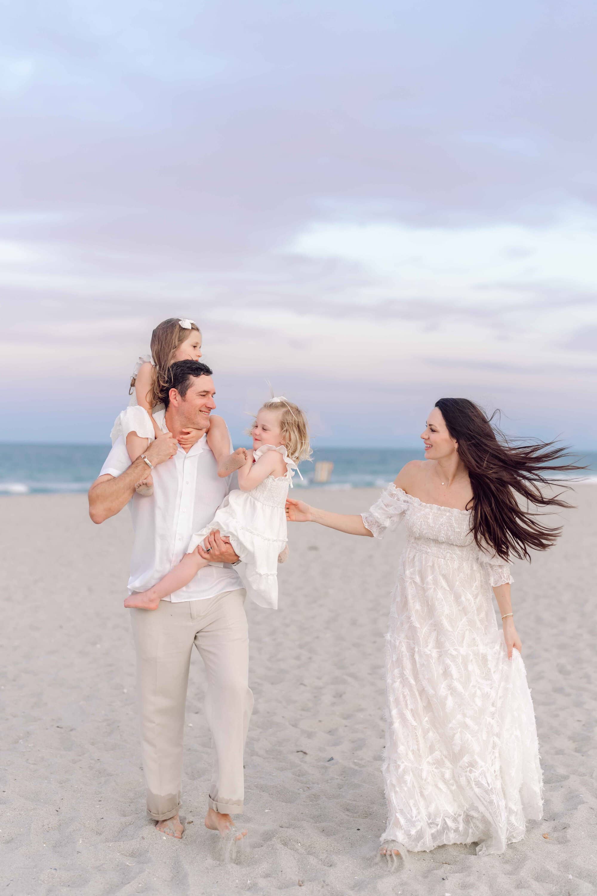 Parents walking with their daughters during a sunset family photography session in Pawleys Island.