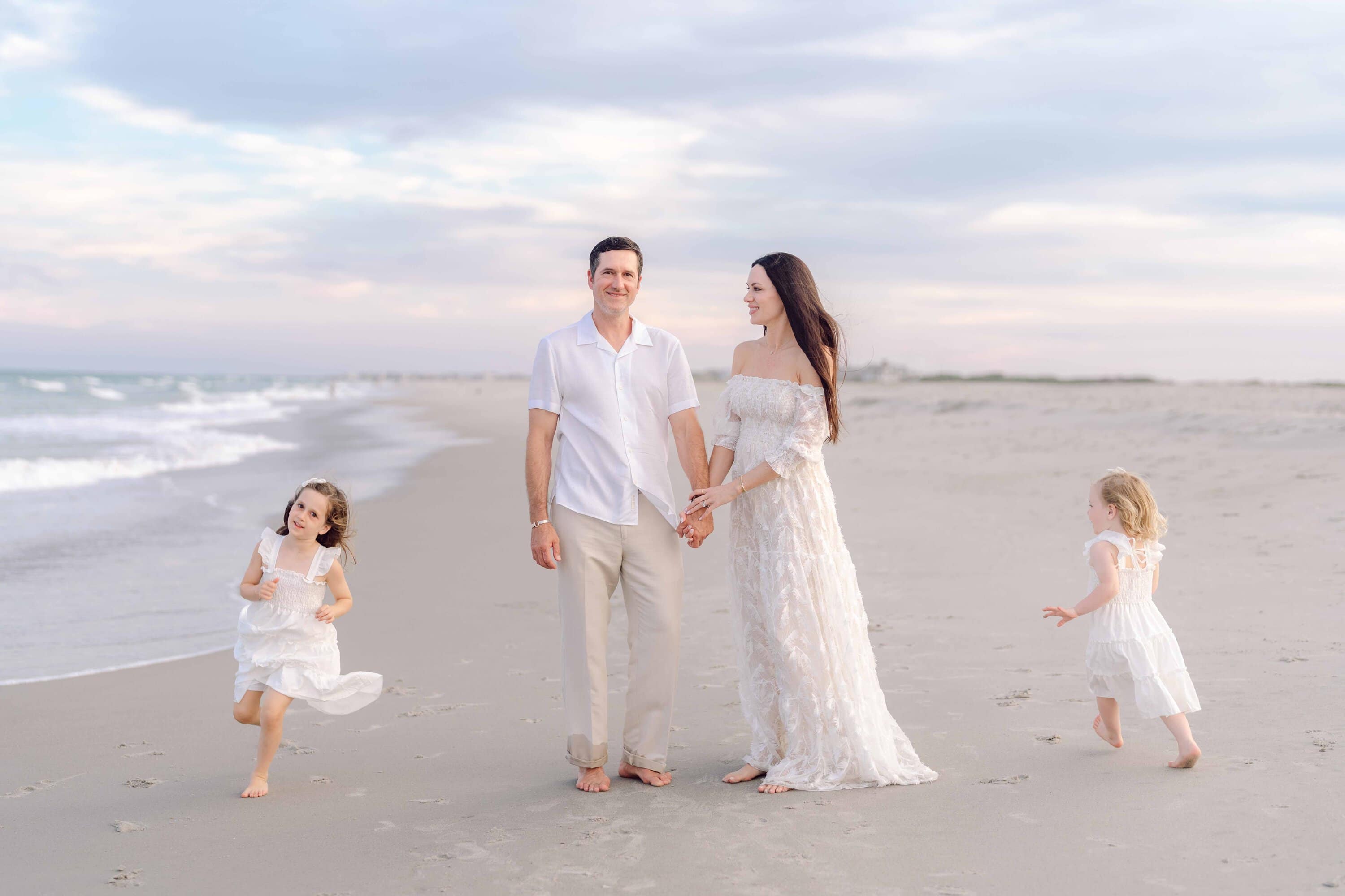 Family walking together along the shoreline in Pawleys Island, South Carolina.