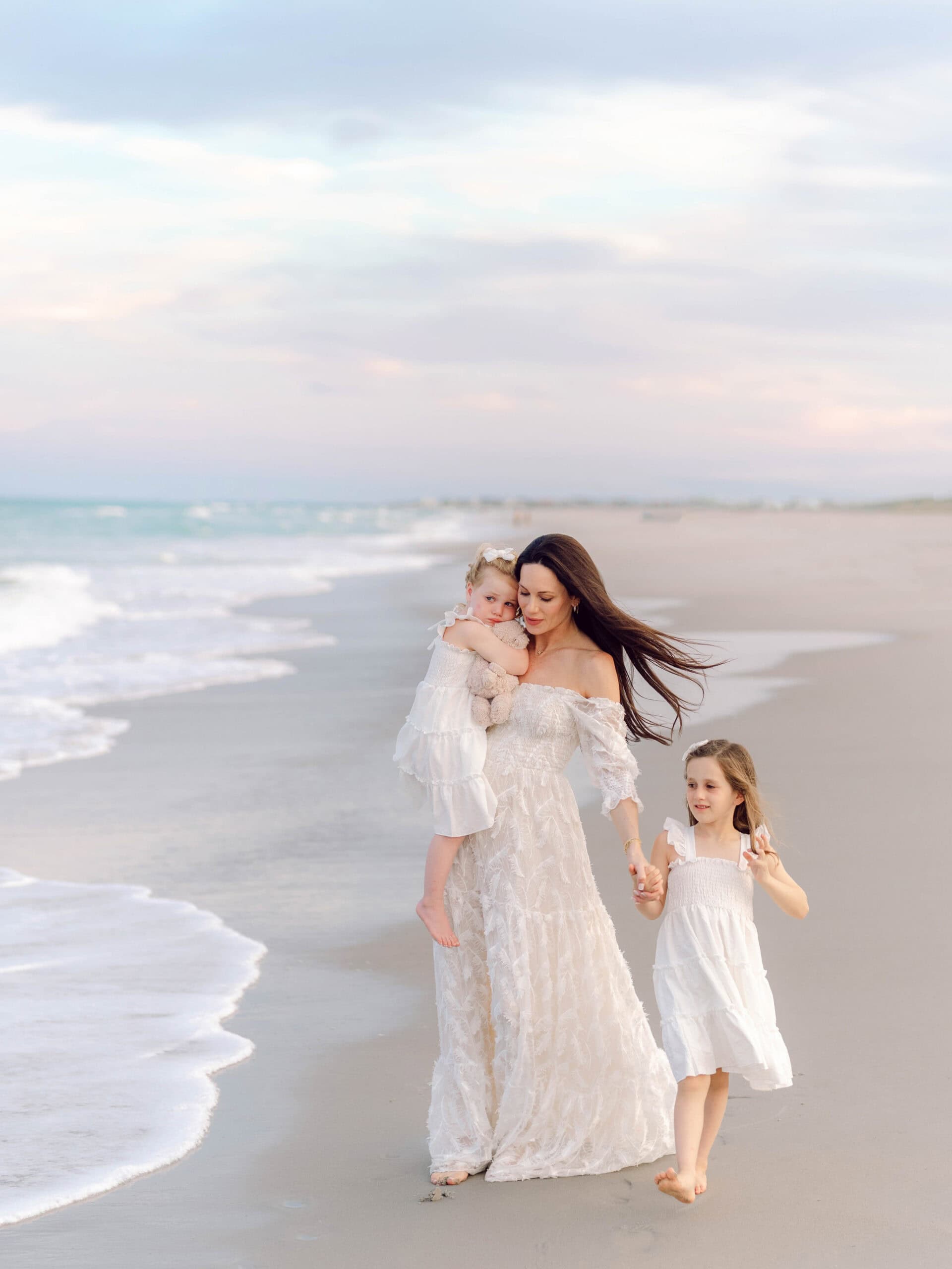 Mother walking on the beach with her two daughters during a Pawleys Island family photography session.