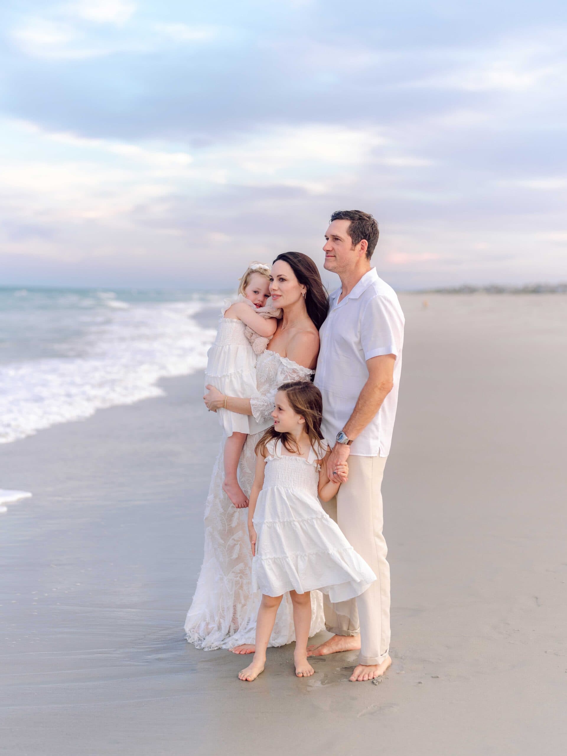 Young girl standing at the edge of the ocean during a Pawleys Island beach portrait session.