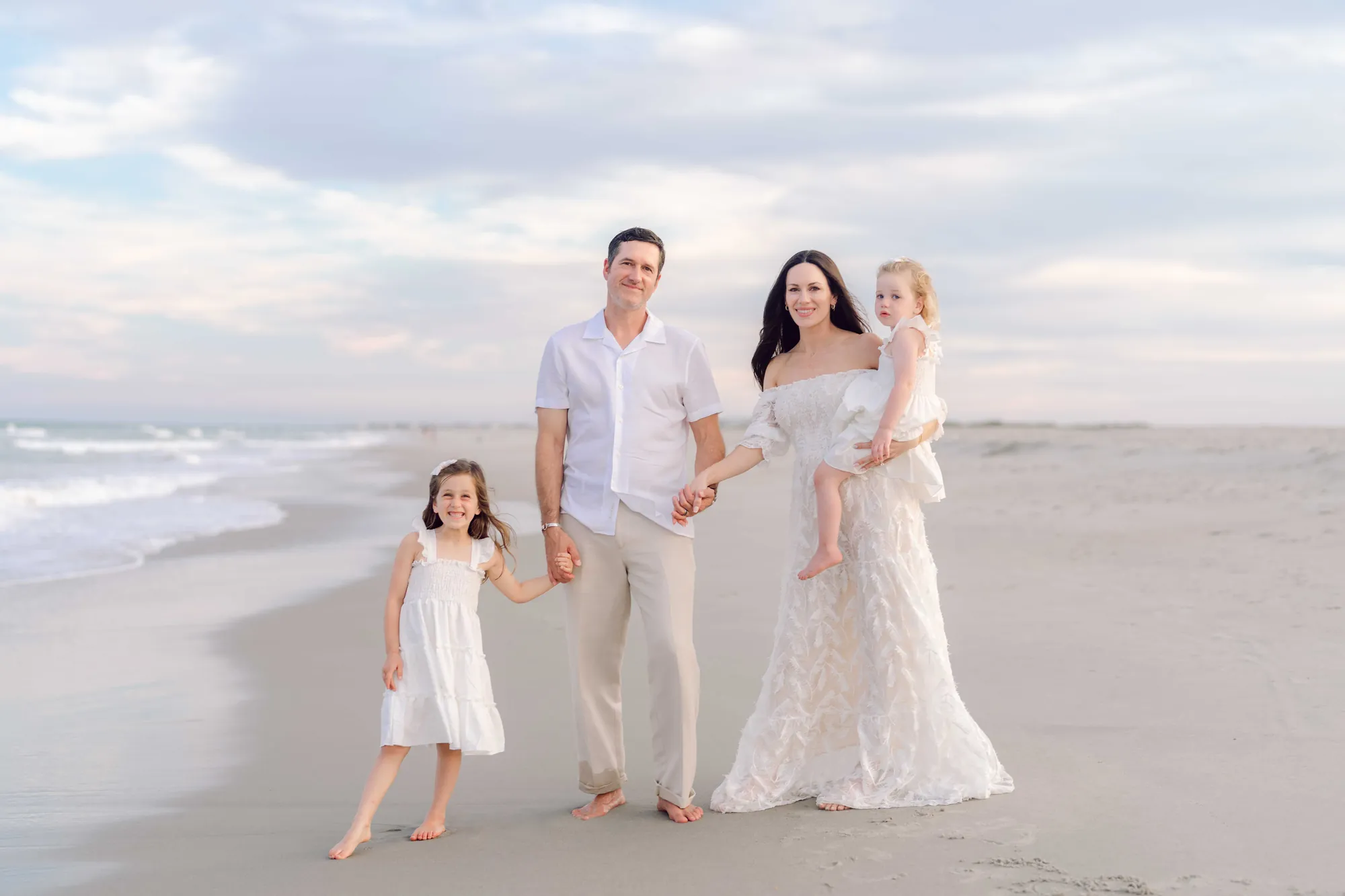 Family portrait on Pawleys Island beach with soft evening light and ocean waves.