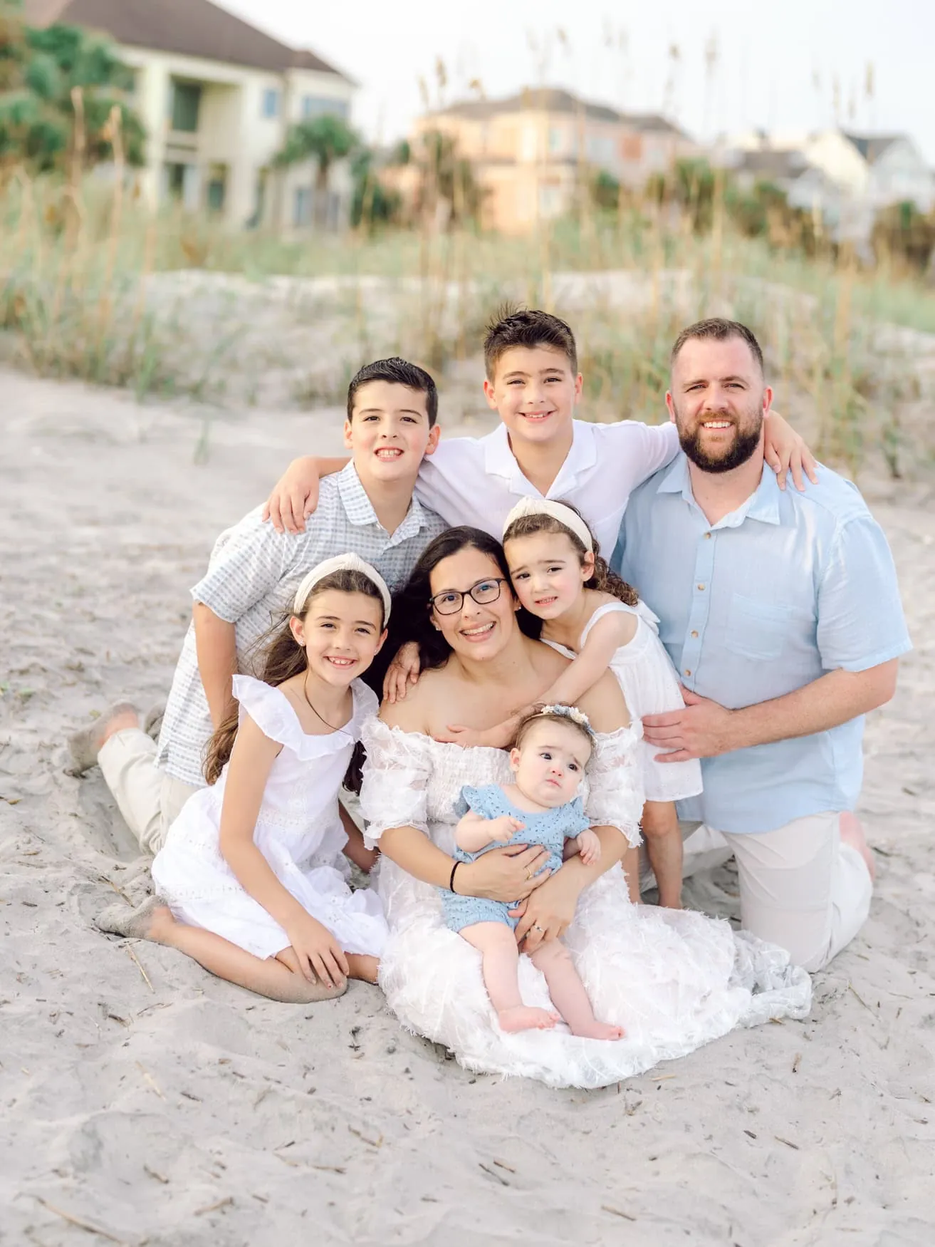 Family portrait on the beach at Isle of Palms near Wild Dunes Resort in Charleston, SC, featuring parents with five children during a golden hour family photography session in the coastal dunes.