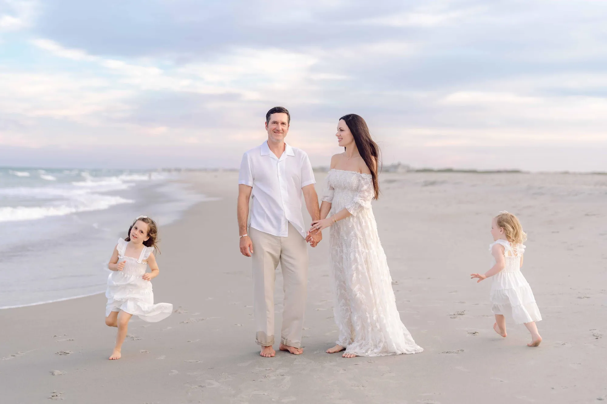 Family walking together along the shoreline in Pawleys Island, South Carolina.