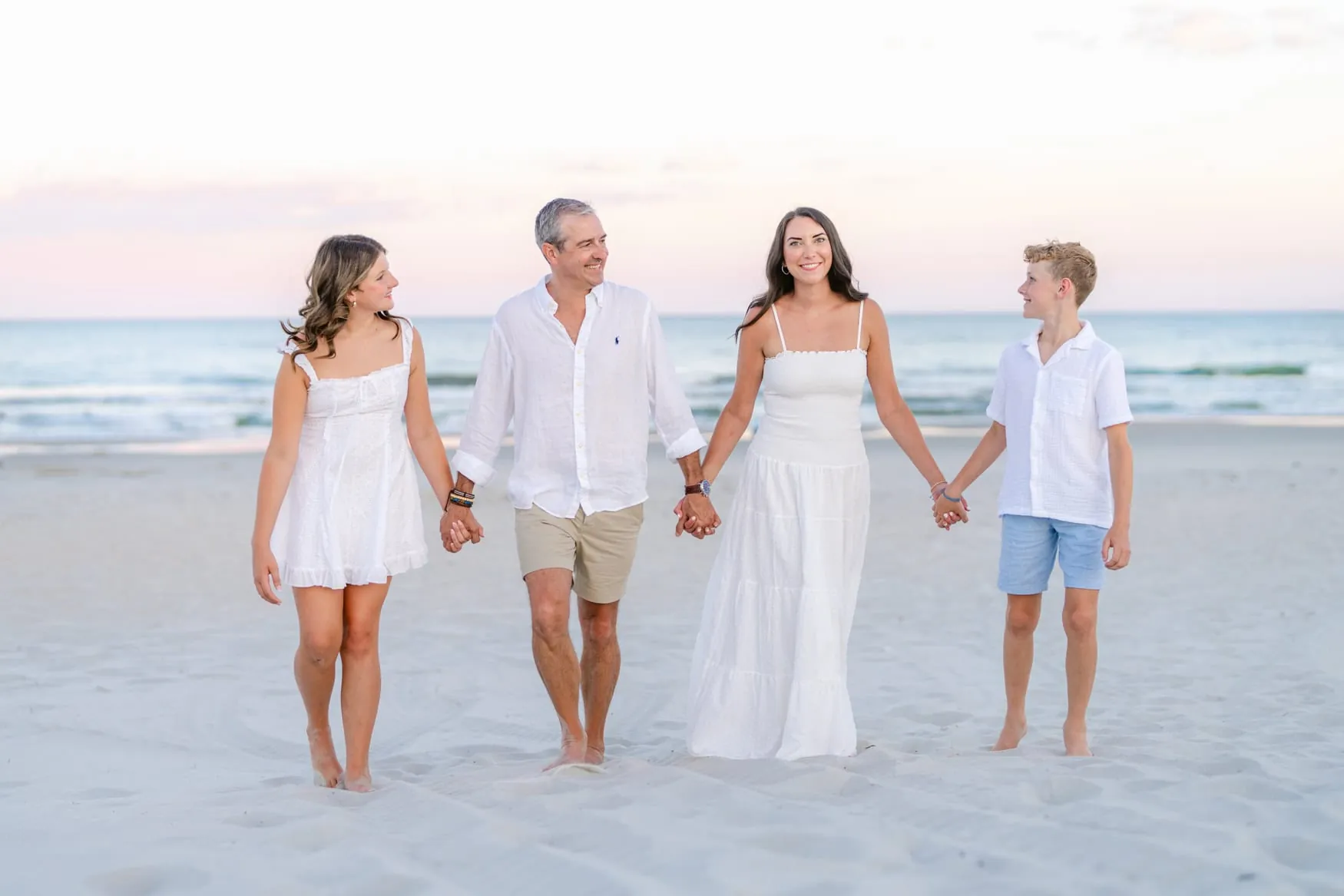 Family wearing soft blue and neutral outfits for family beach photos in Myrtle Beach, South Carolina.