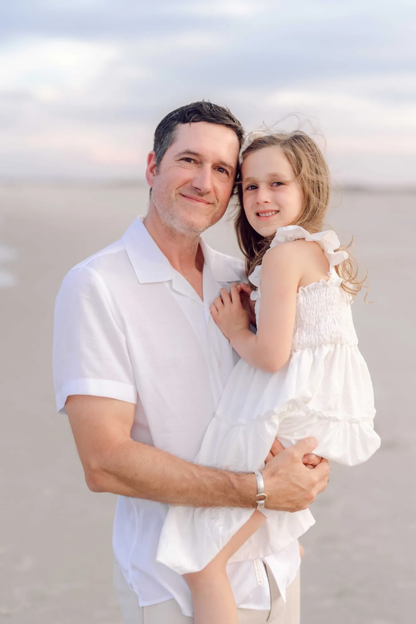 Father holding his daughter during a Pawleys Island family photography session on the beach.