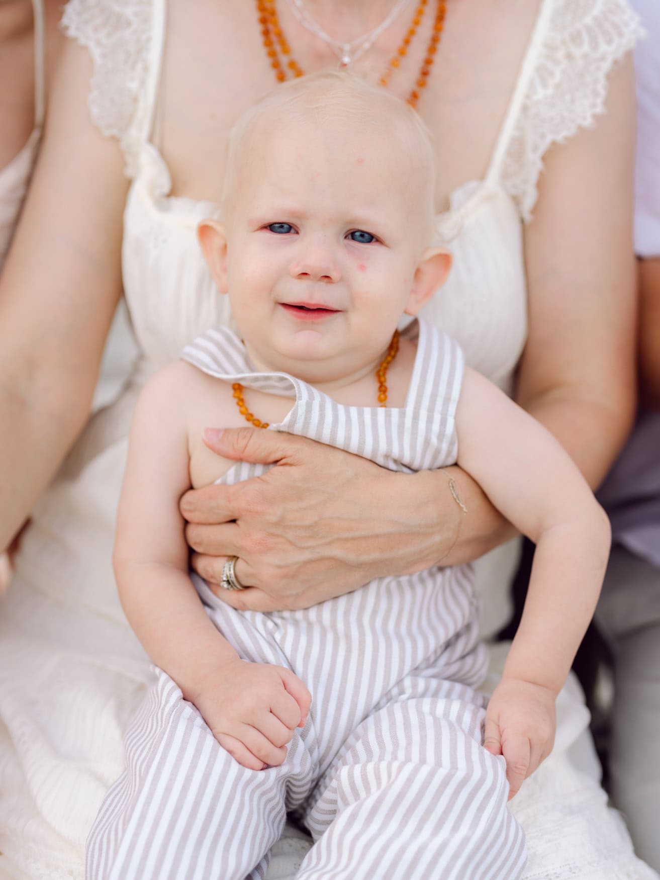 Toddler girl smiling during a family beach photography session at Wild Dunes Resort in Isle of Palms near Charleston, South Carolina. Natural child portrait captured in soft evening light during a beach vacation.
