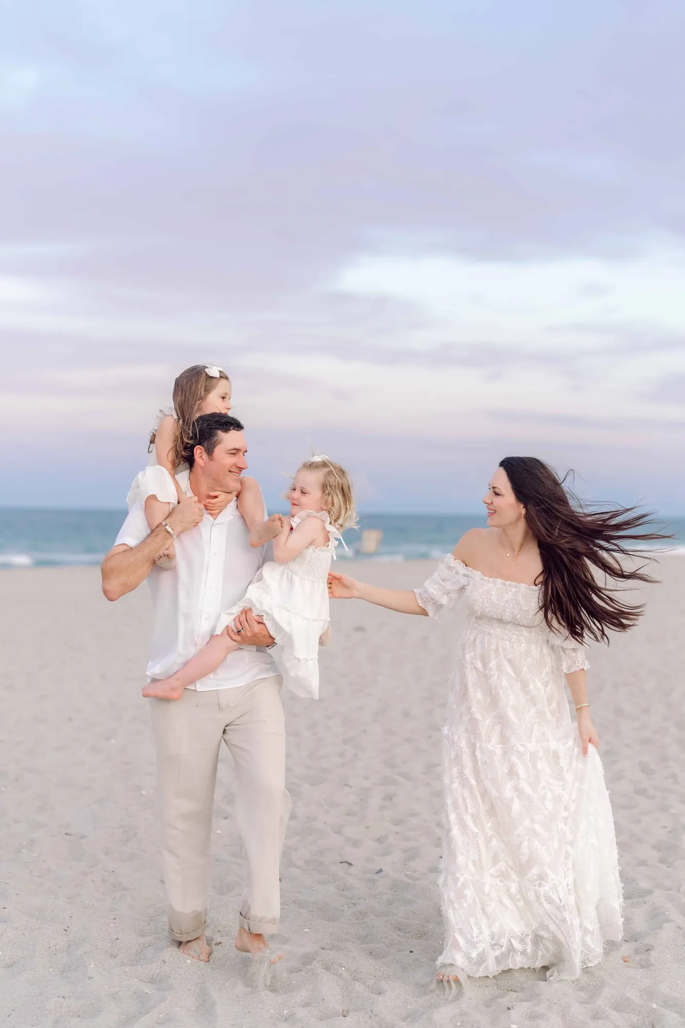 Parents walking with their daughters during a sunset family photography session in Pawleys Island.