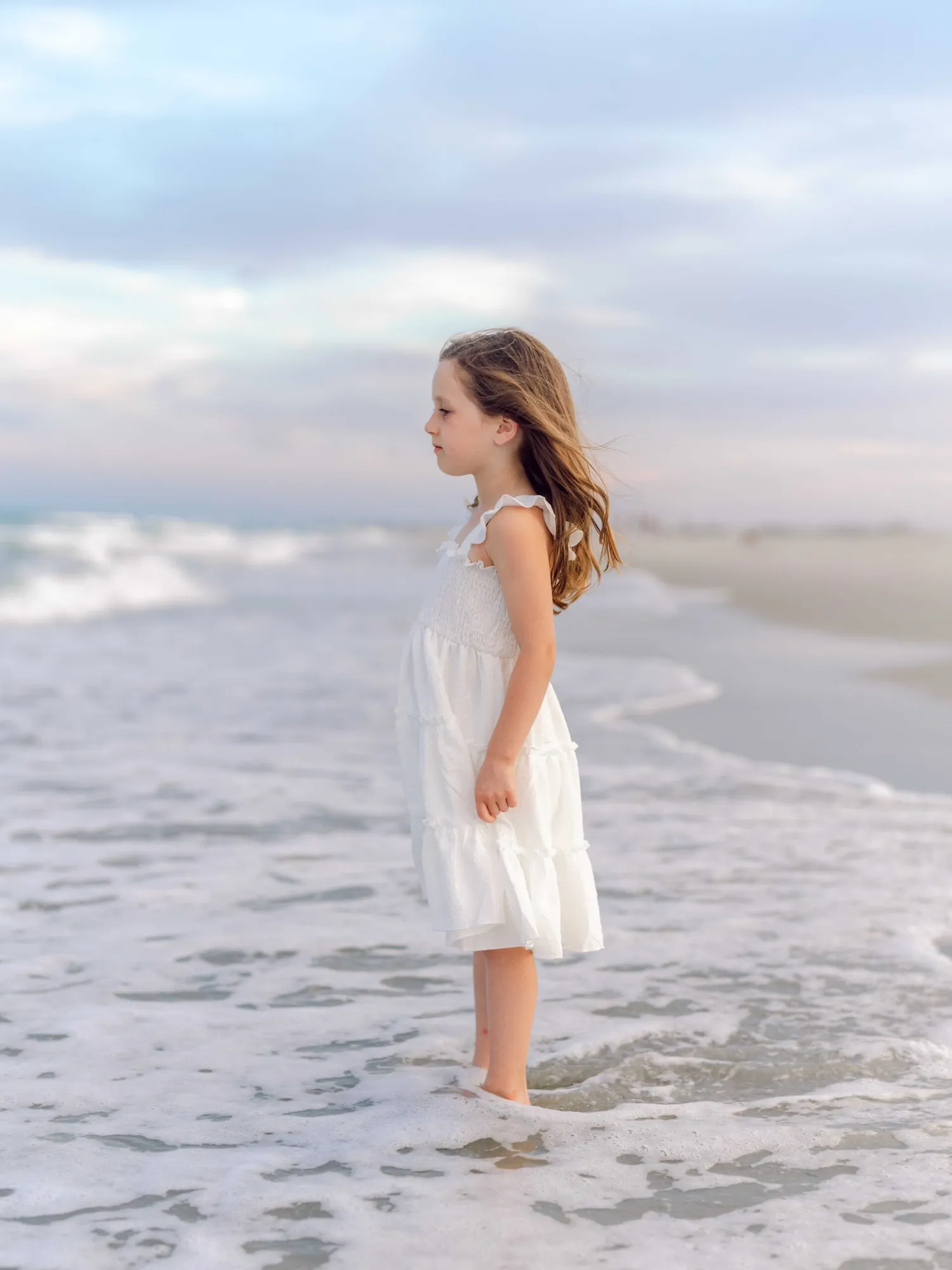 Young girl smiling on the beach during a Pawleys Island family photography session.