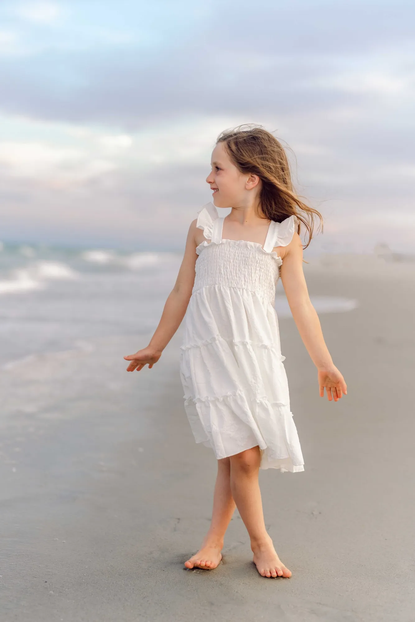 Young girl standing by the ocean during a Pawleys Island family photo session.