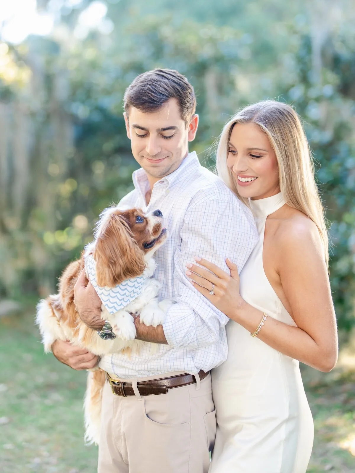 Engaged couple holding their dog under Spanish moss in Charleston SC