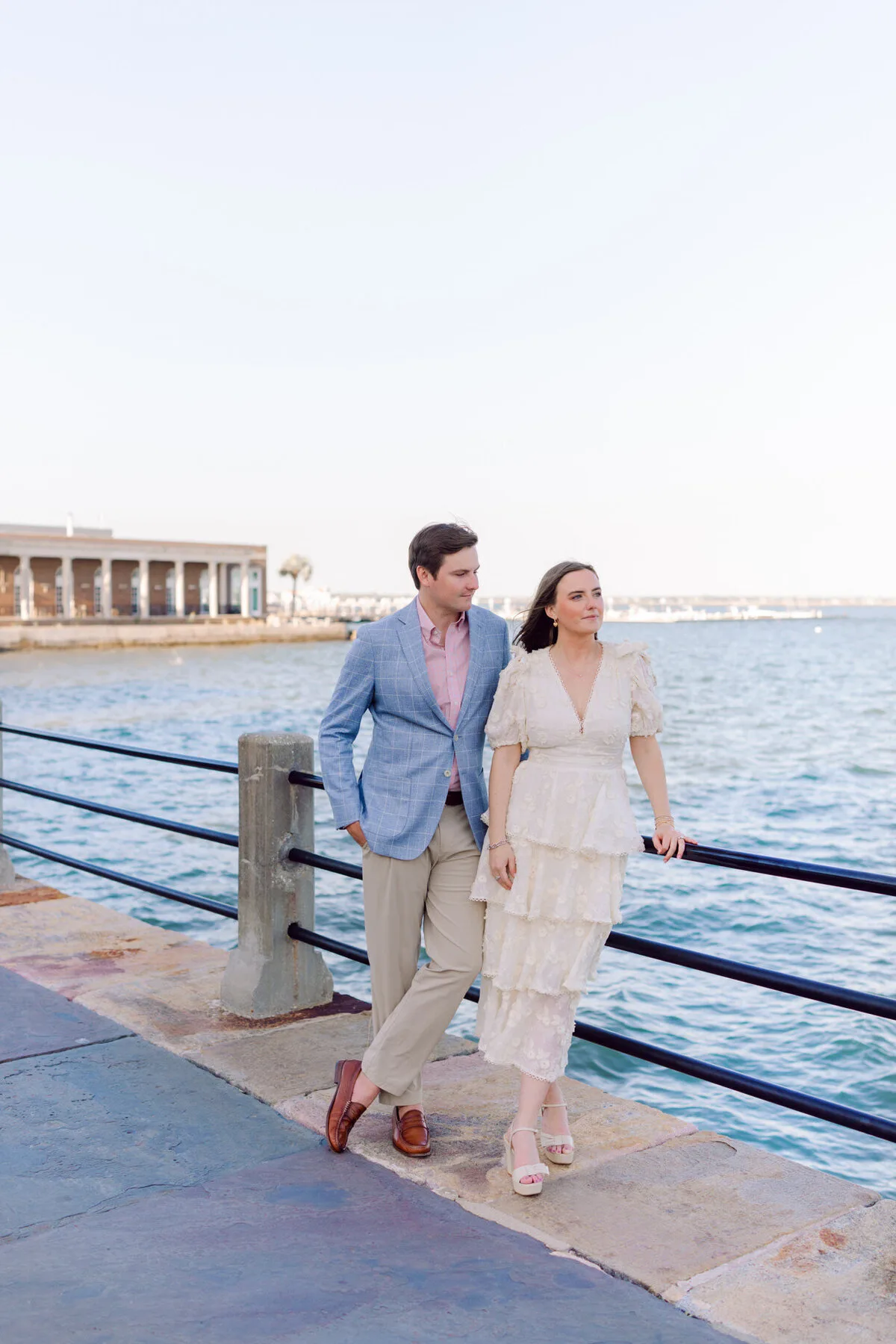Engaged couple walking along the Charleston waterfront at The Battery