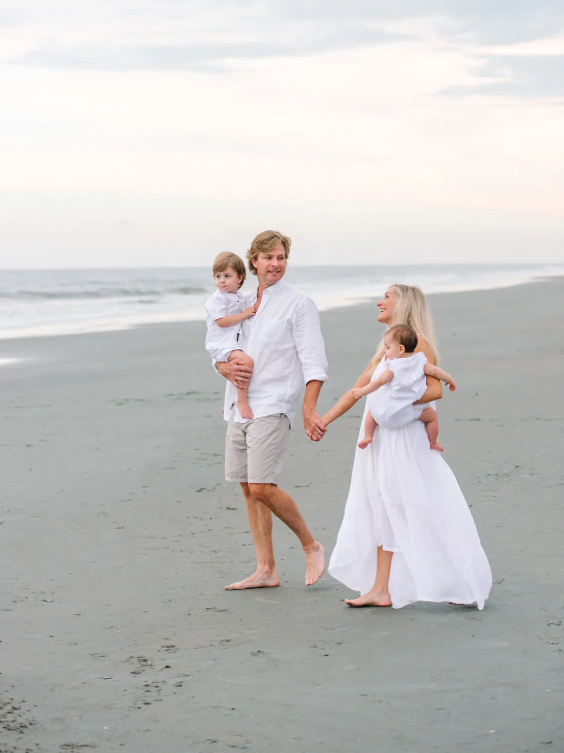 Parents carrying their children along the shore near Charleston SC