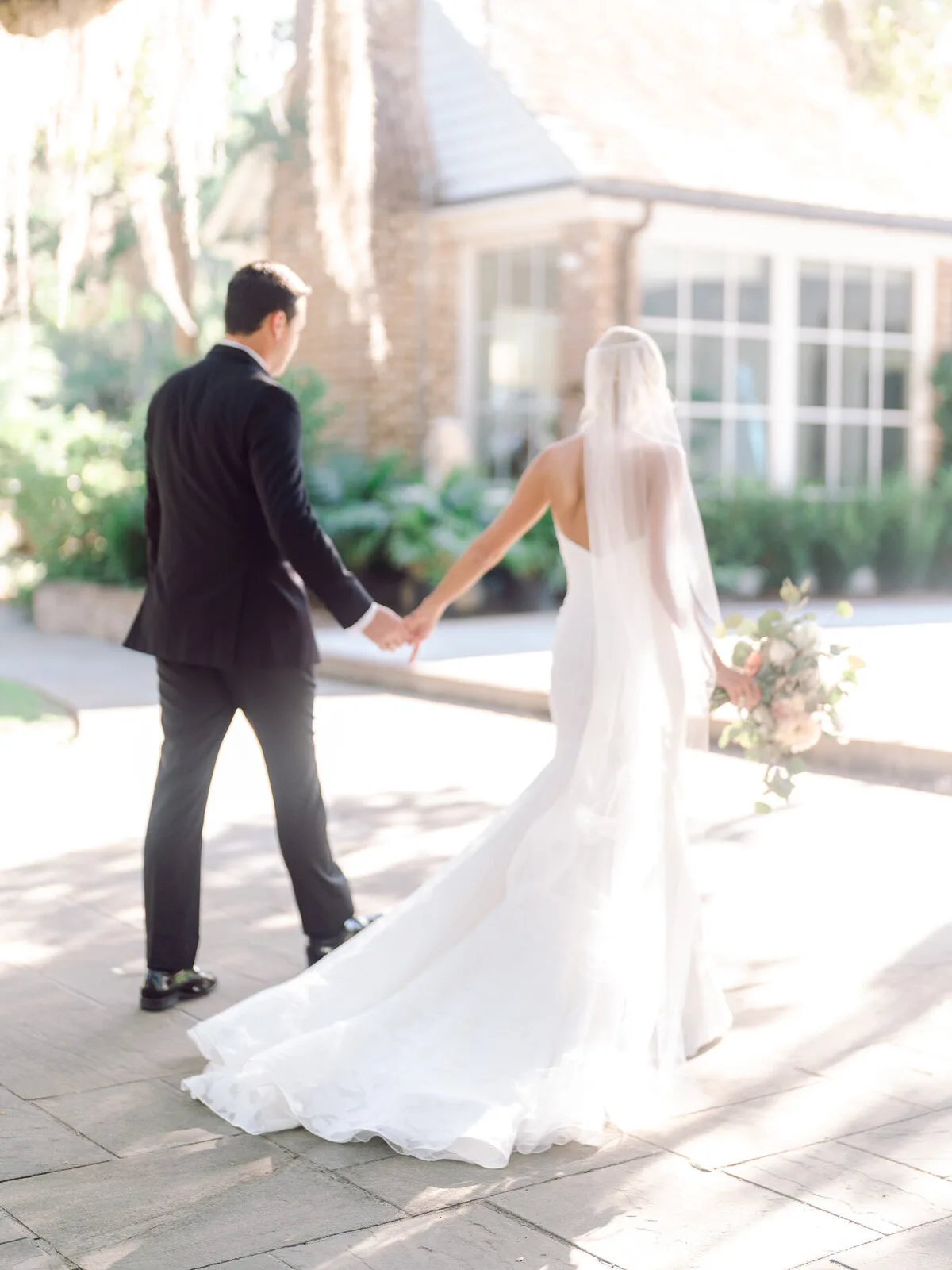 Couple walking hand in hand up the drive at a Charleston SC wedding